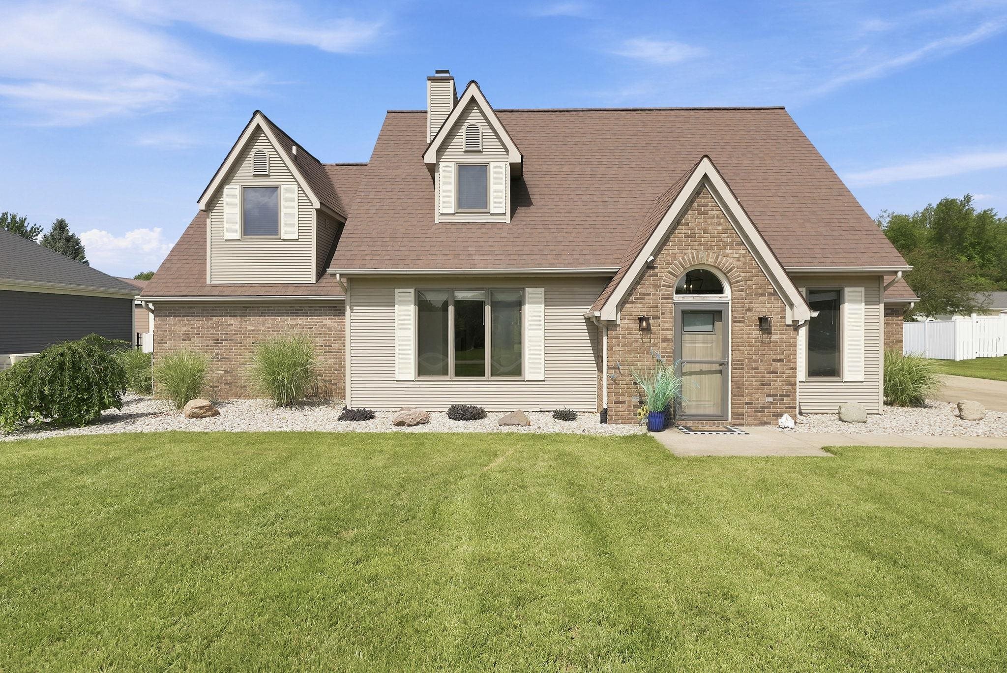 Exterior featuring a brick and siding facade with dormer windows