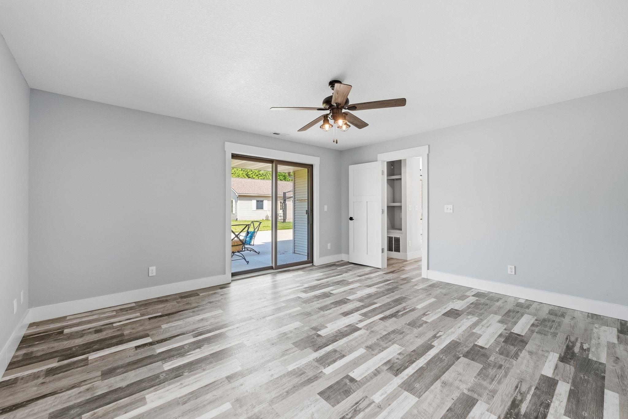 Spacious room featuring wood-finish flooring, light gray walls, and white trim