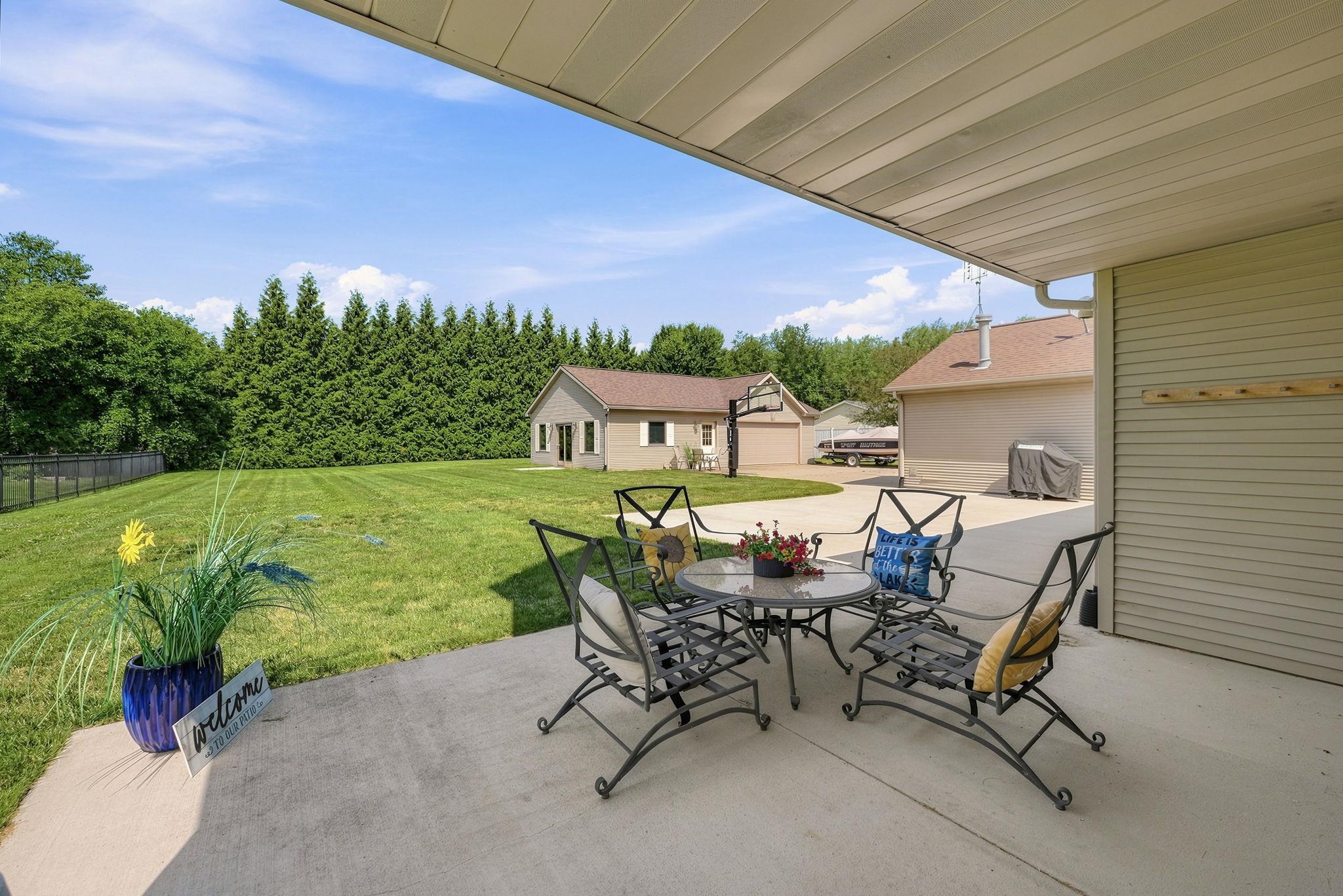 Covered patio area featuring a concrete surface and a spacious grassy yard