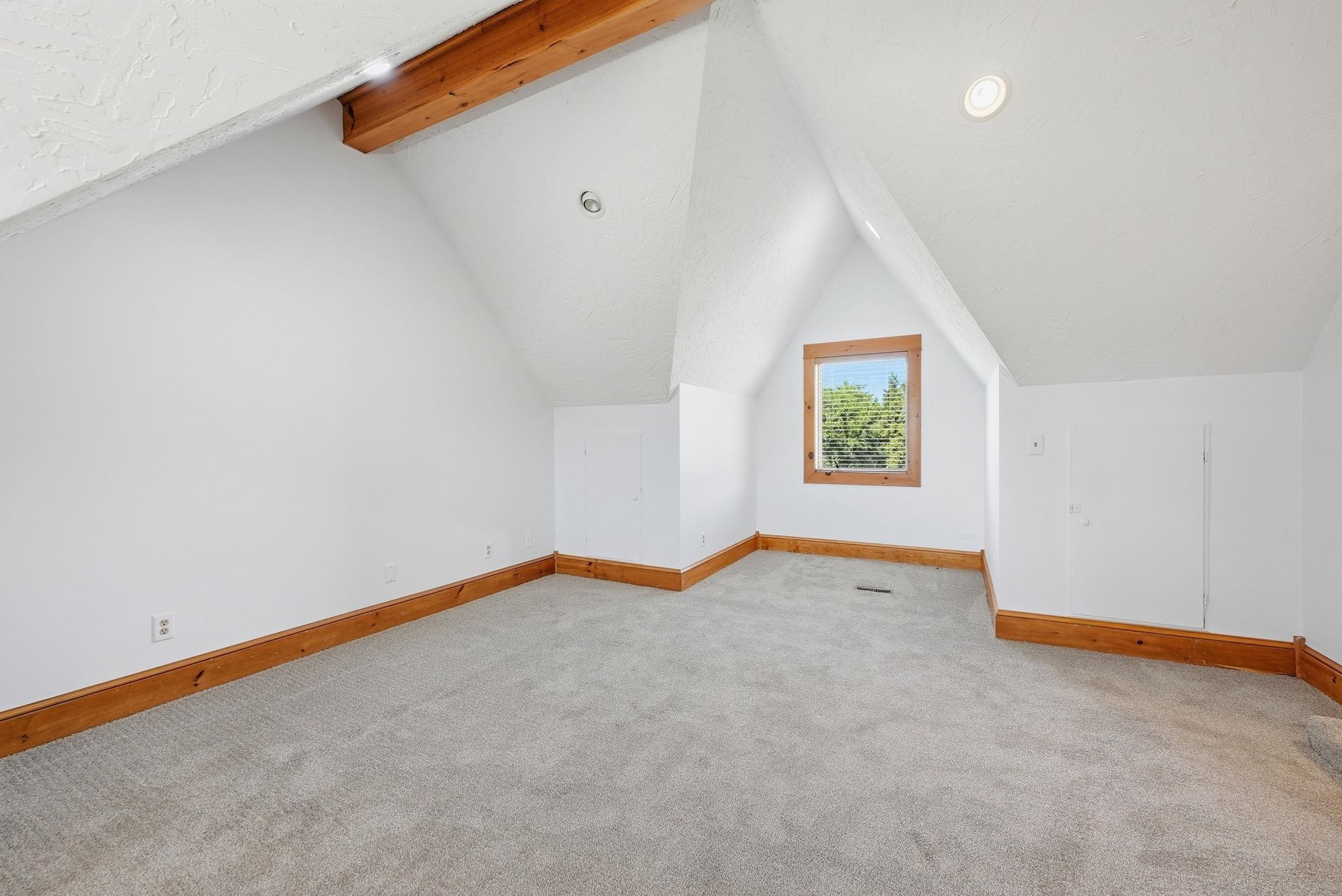 NEW Paint and CARPET and new stained wood door featuring sloped ceilings, recessed lighting, a wood-framed window, gray carpeting, and natural wood trim
