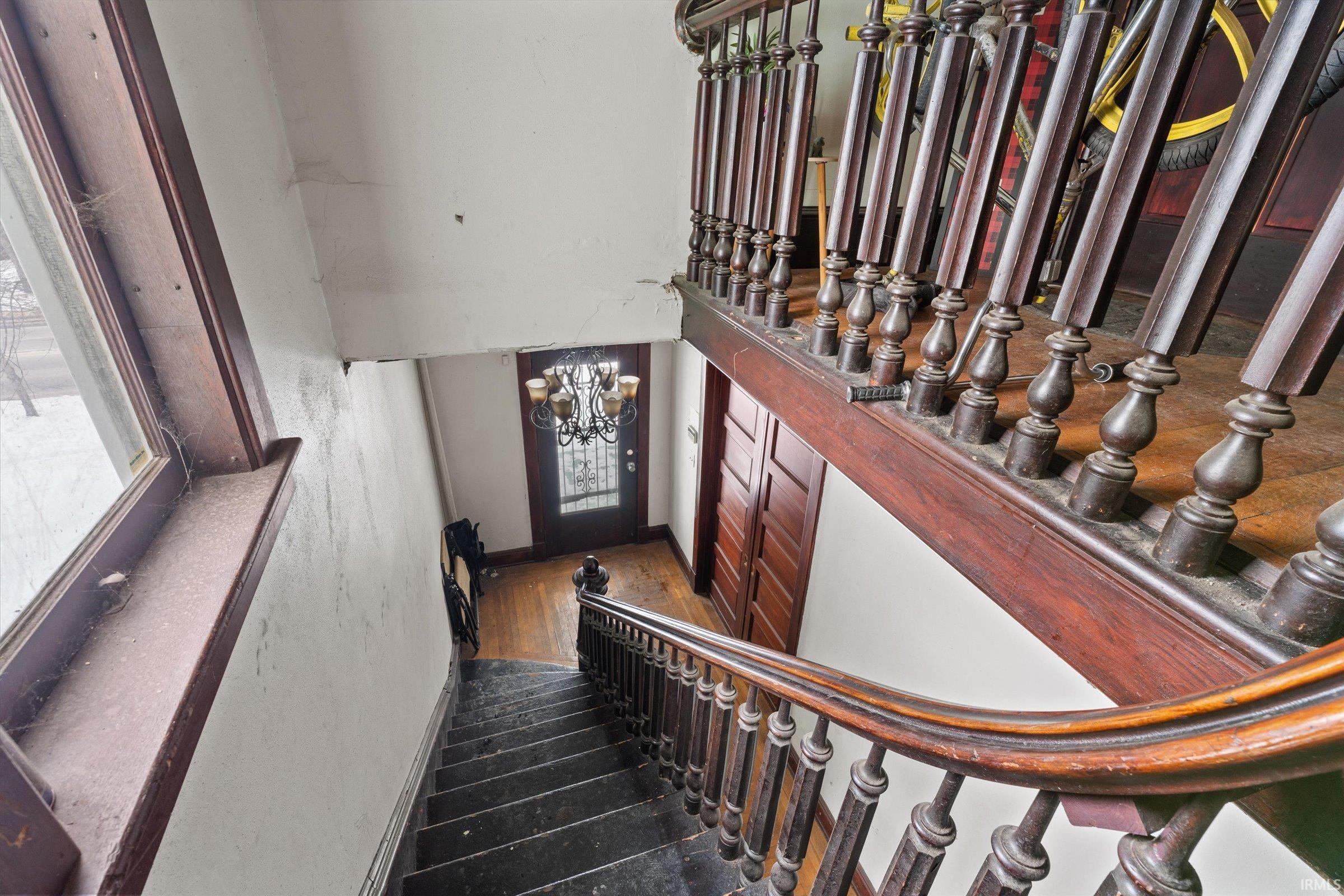 Staircase with a chandelier and baseboards
