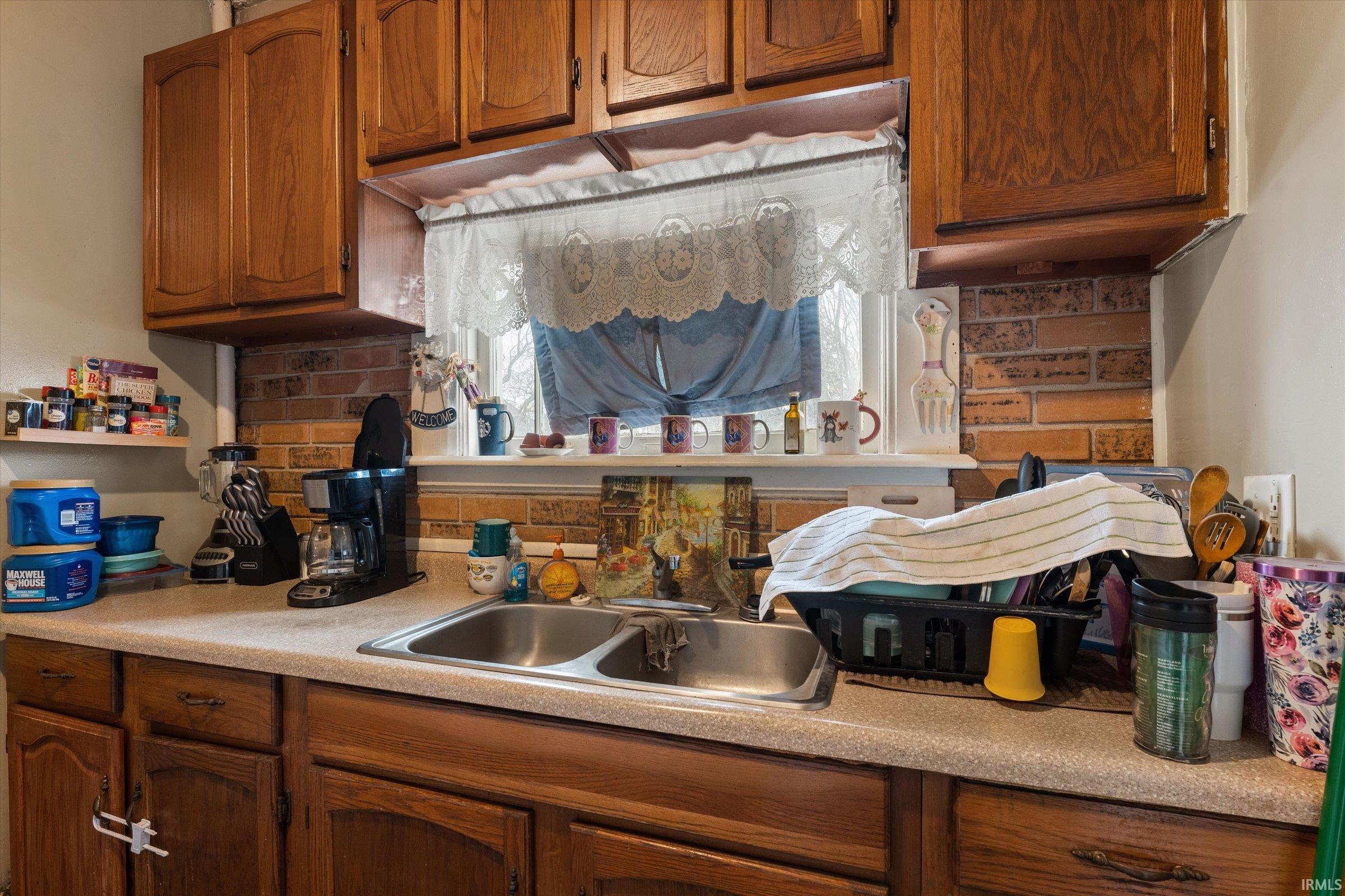 Kitchen with wood finish cabinets, light countertops, and tasteful backsplash
