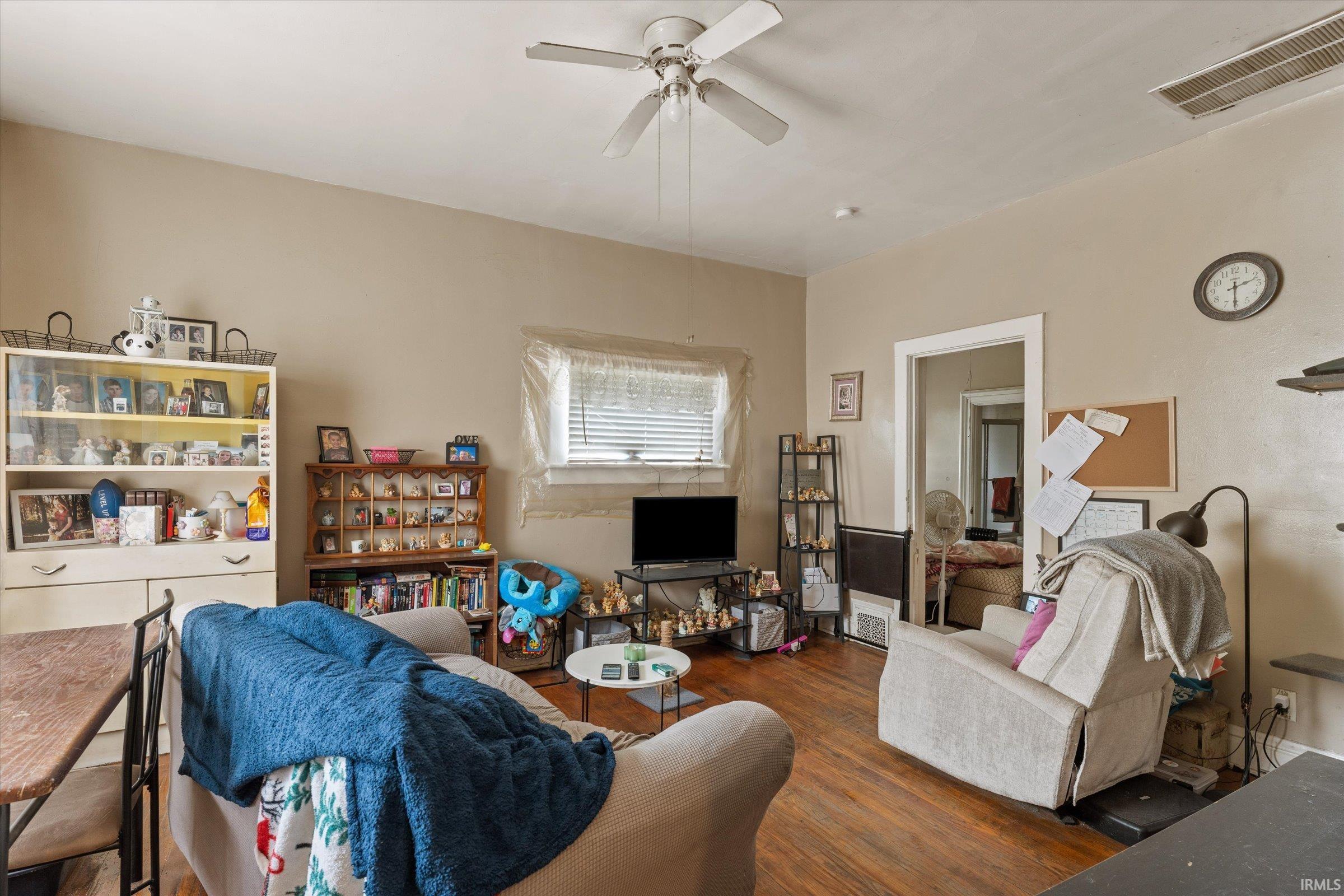 Living area featuring wood finished floors and a ceiling fan