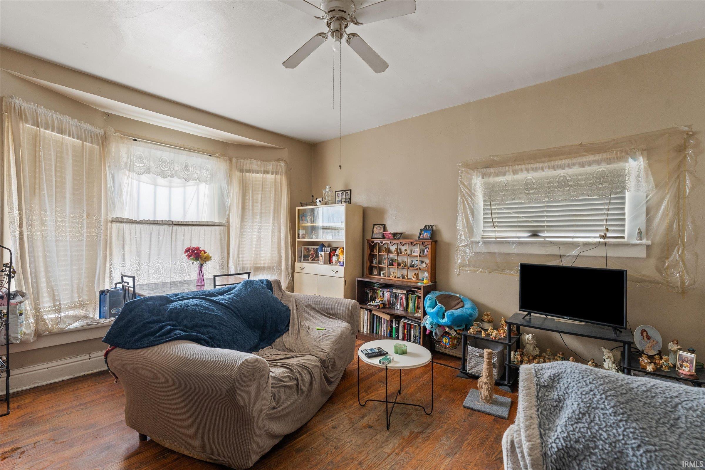 Living room featuring hardwood / wood-style flooring and ceiling fan