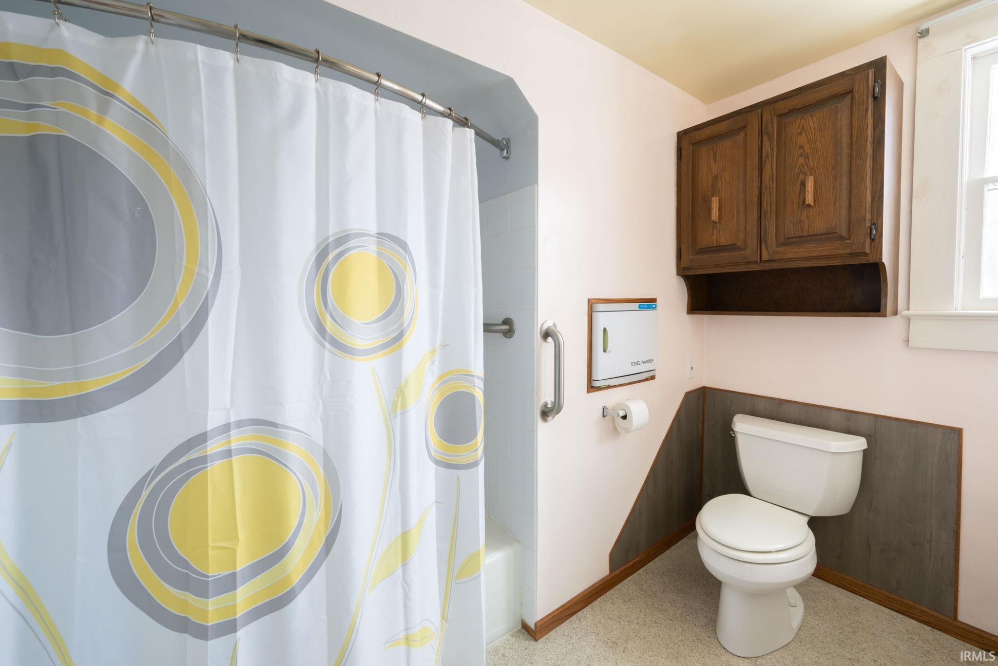 Bathroom featuring shower / bathtub combination with curtain and toilet