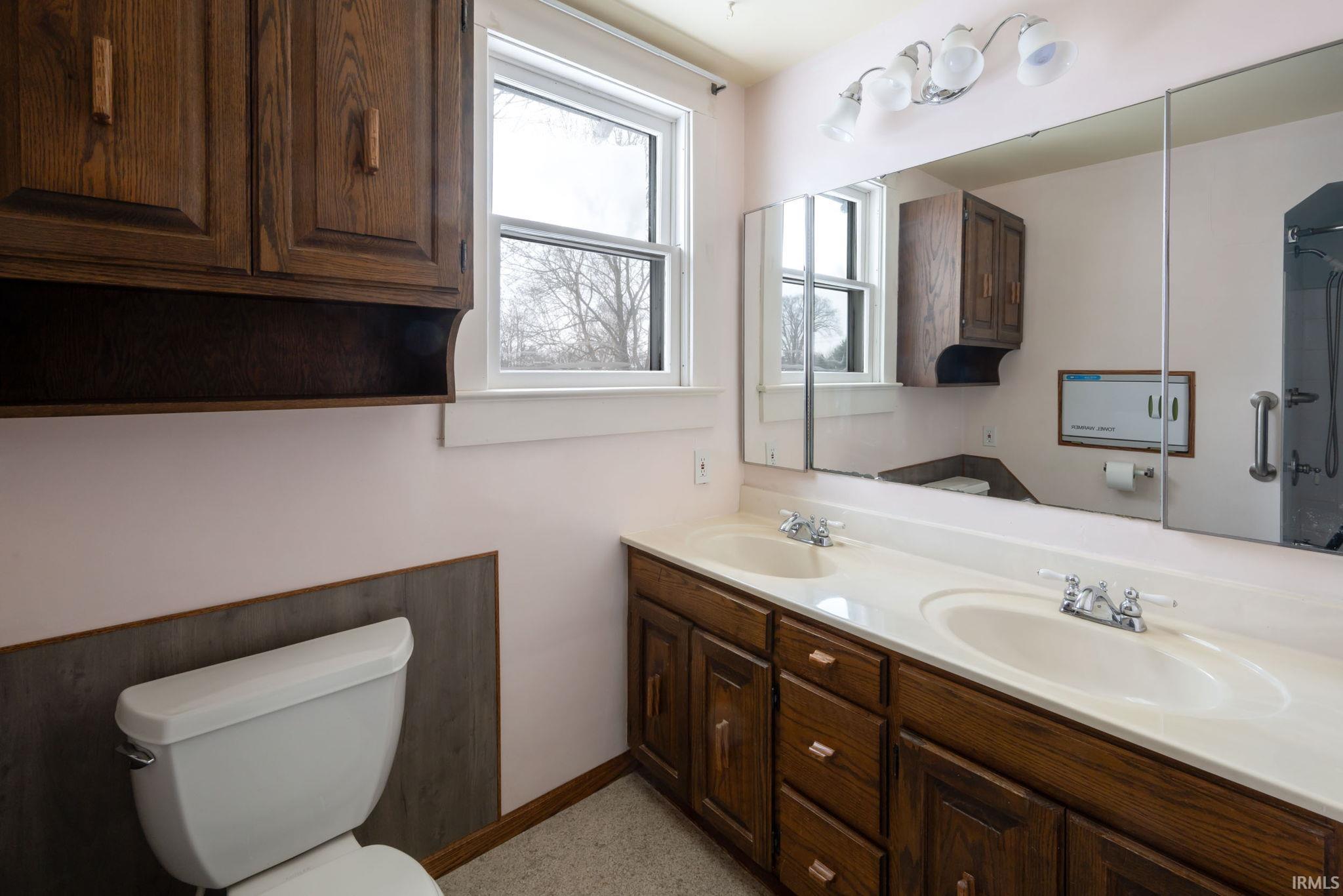 Full bathroom featuring double vanity and a shower