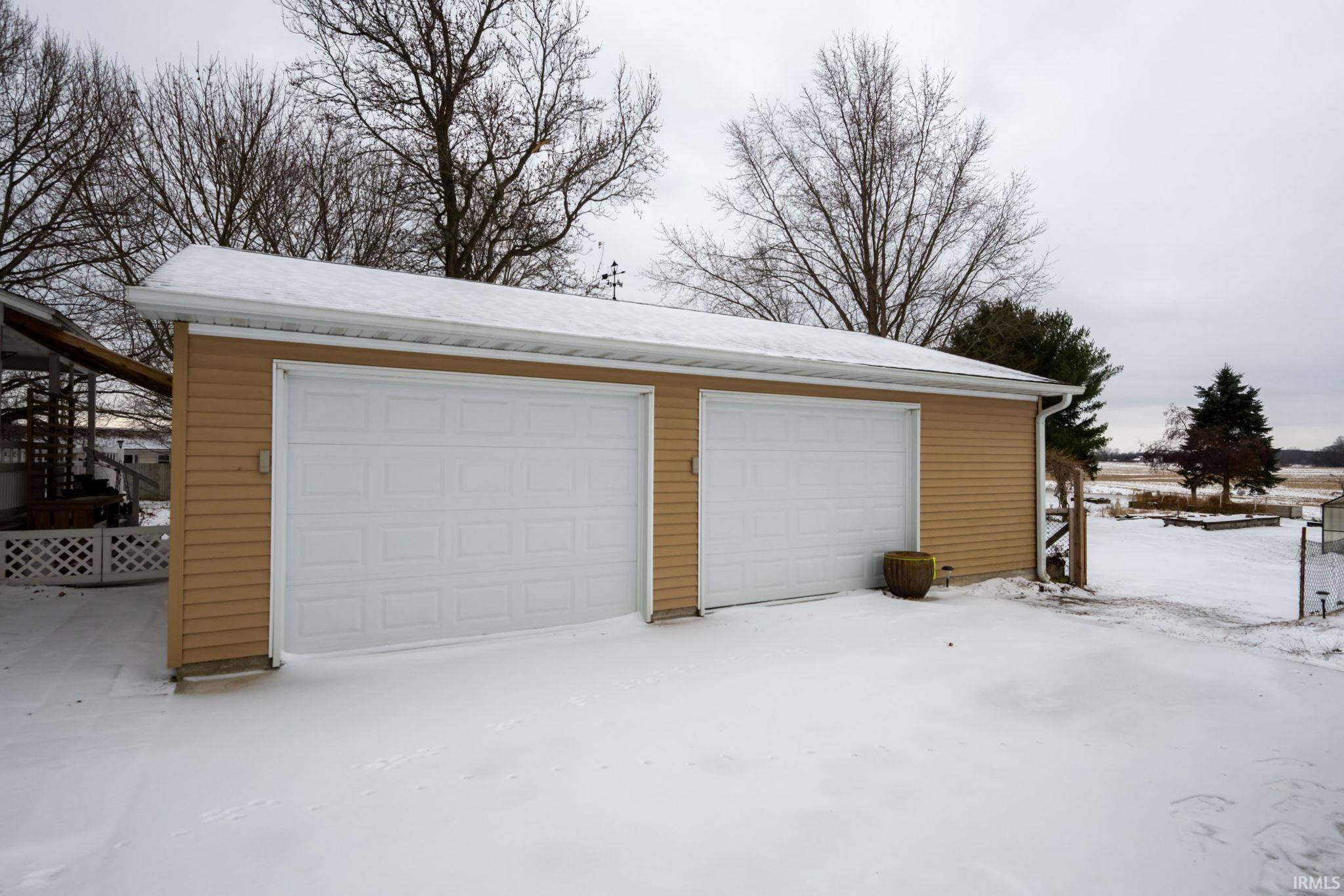 Snow covered garage featuring a garage