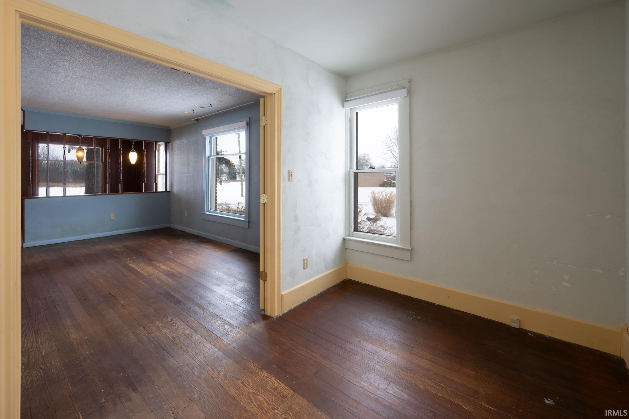 Empty room featuring dark wood finished floors and baseboards