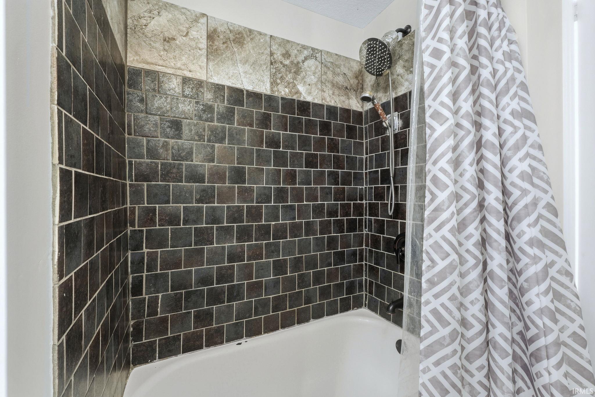 Bathroom featuring shower / bathtub combination with curtain