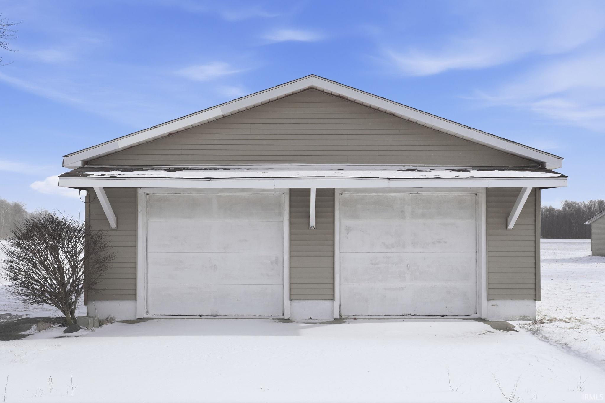 Snow covered garage with a garage