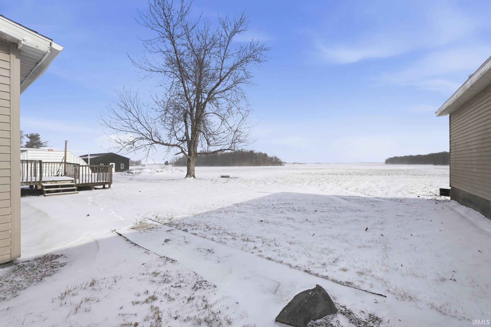 Yard covered in snow featuring a deck