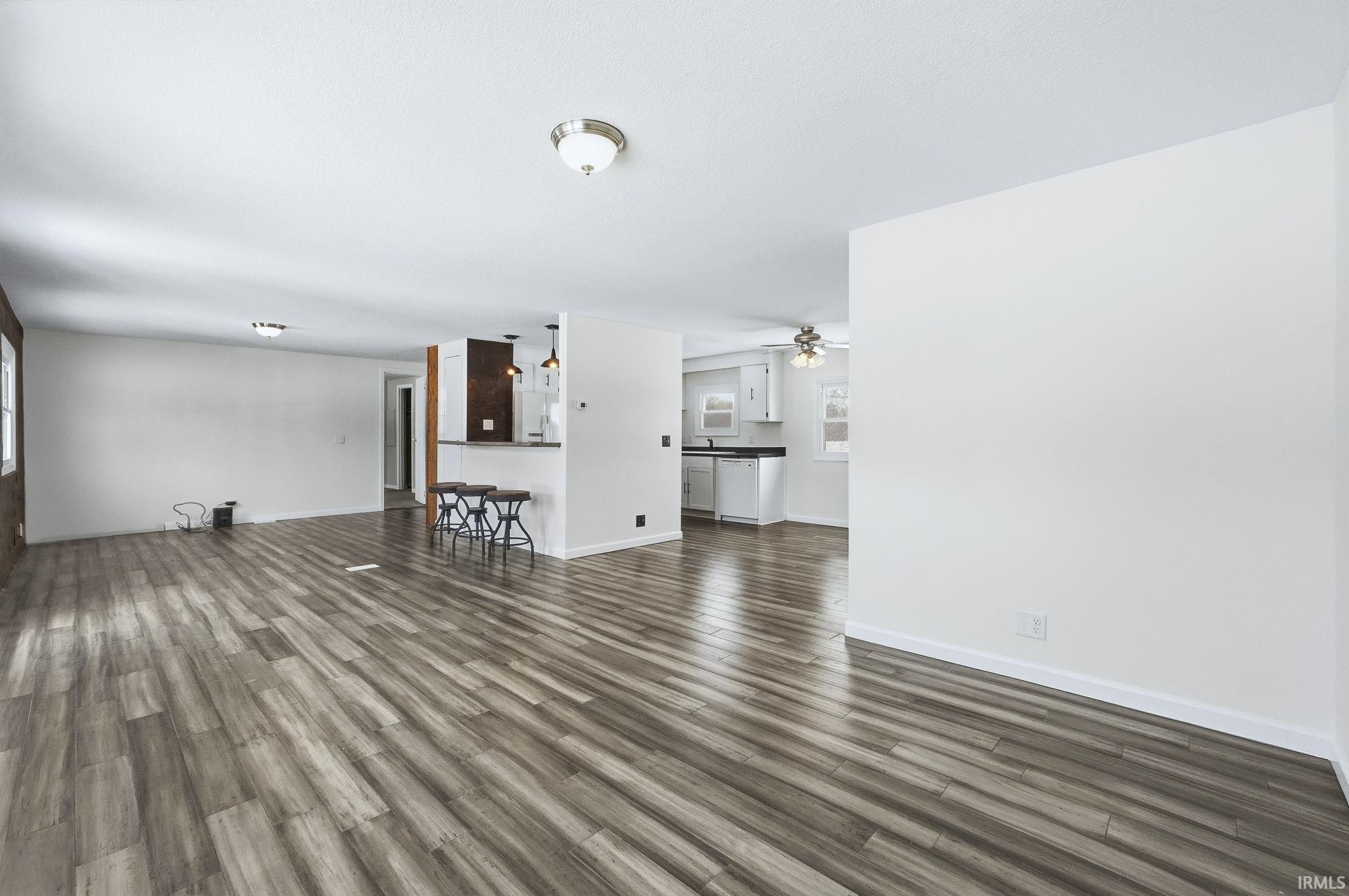 Unfurnished living room with dark wood-style flooring