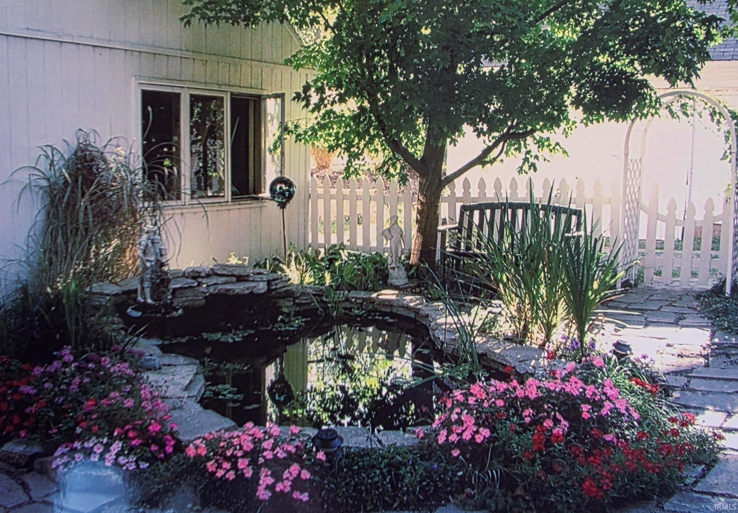 View of side of property with a small pond