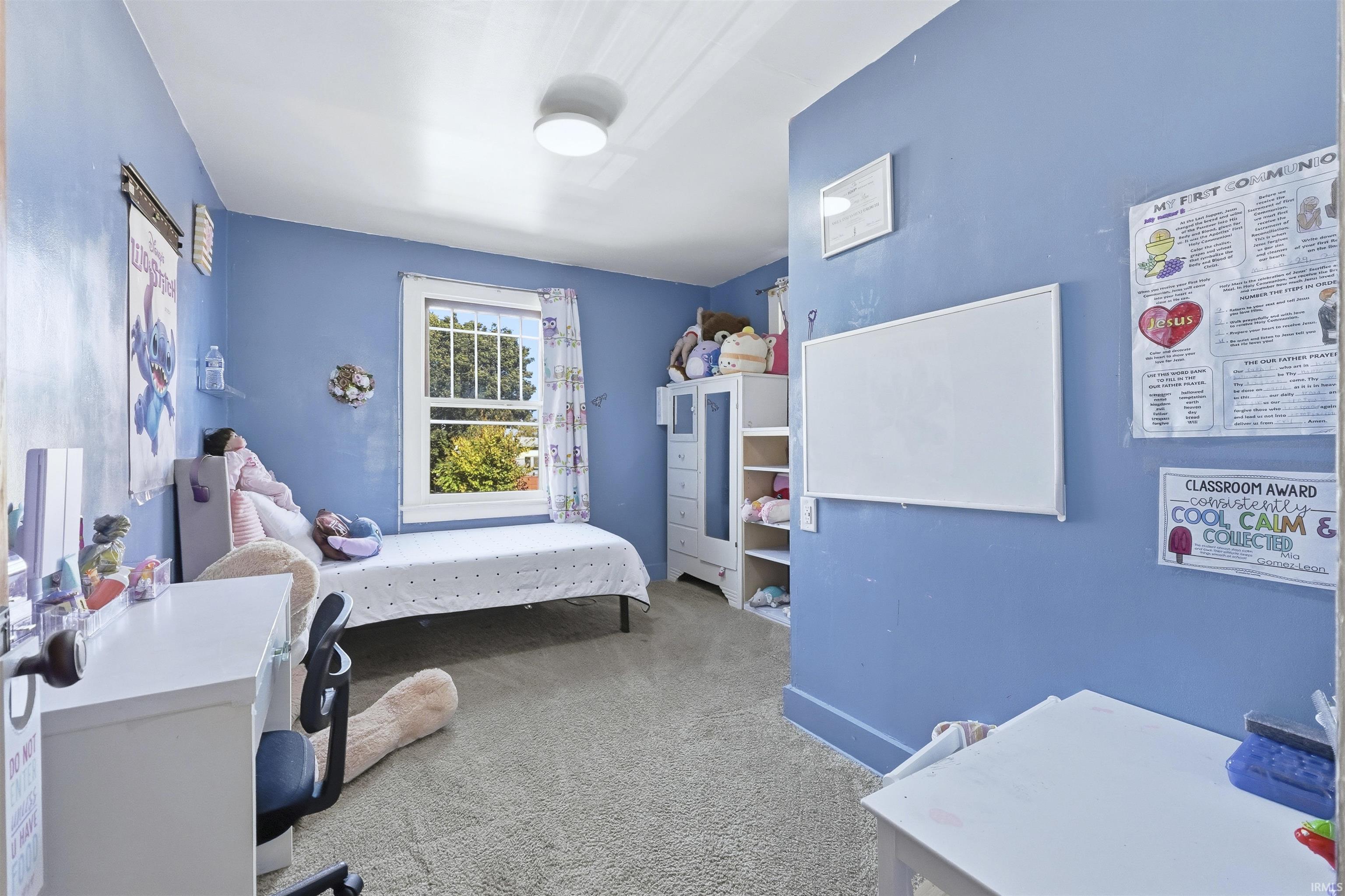Bedroom featuring light carpet and baseboards