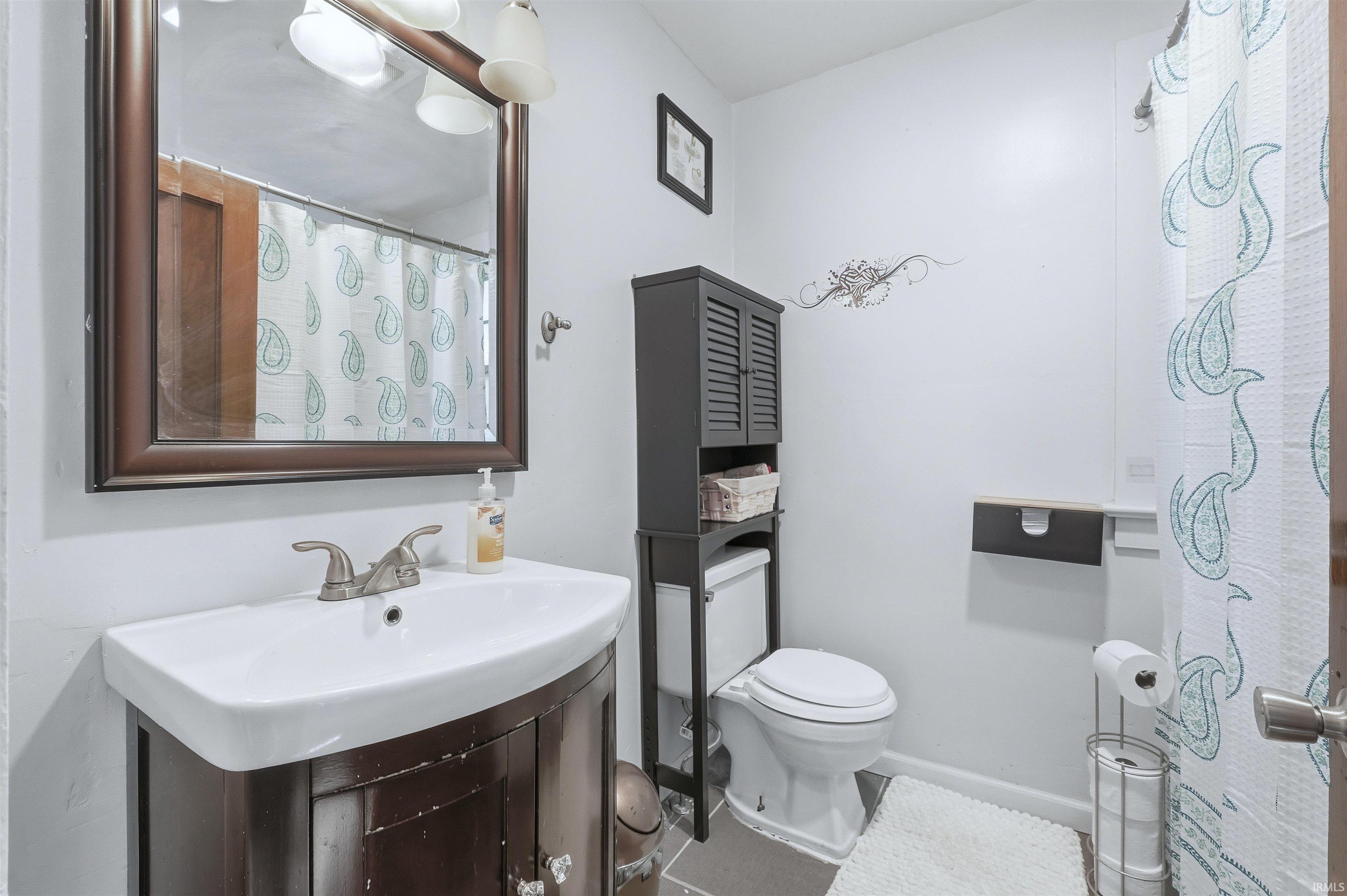 Full bath with vanity, a shower with curtain, and tile patterned flooring