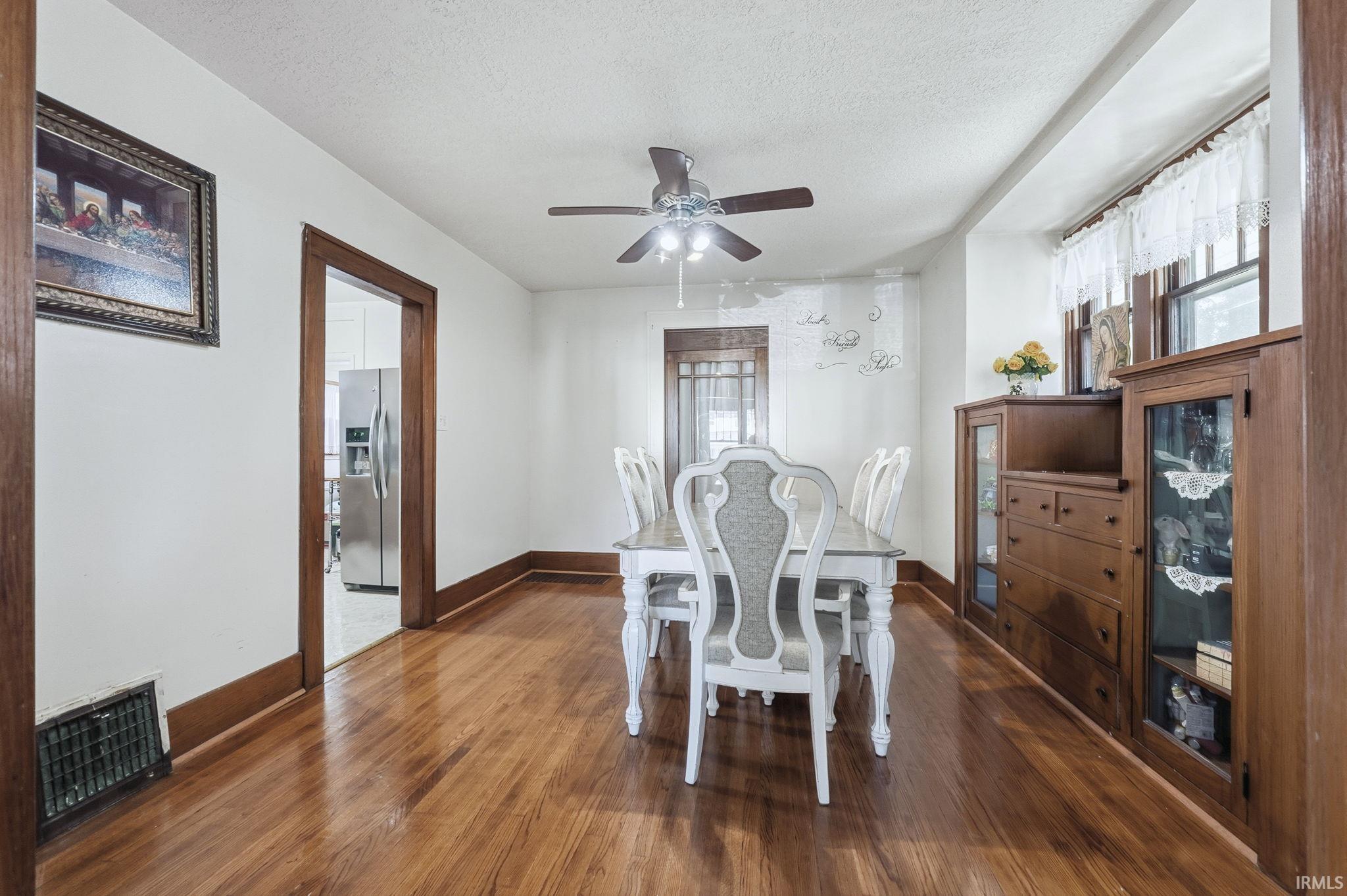 Dining area featuring dark wood-type flooring, a textured ceiling, and ceiling fan