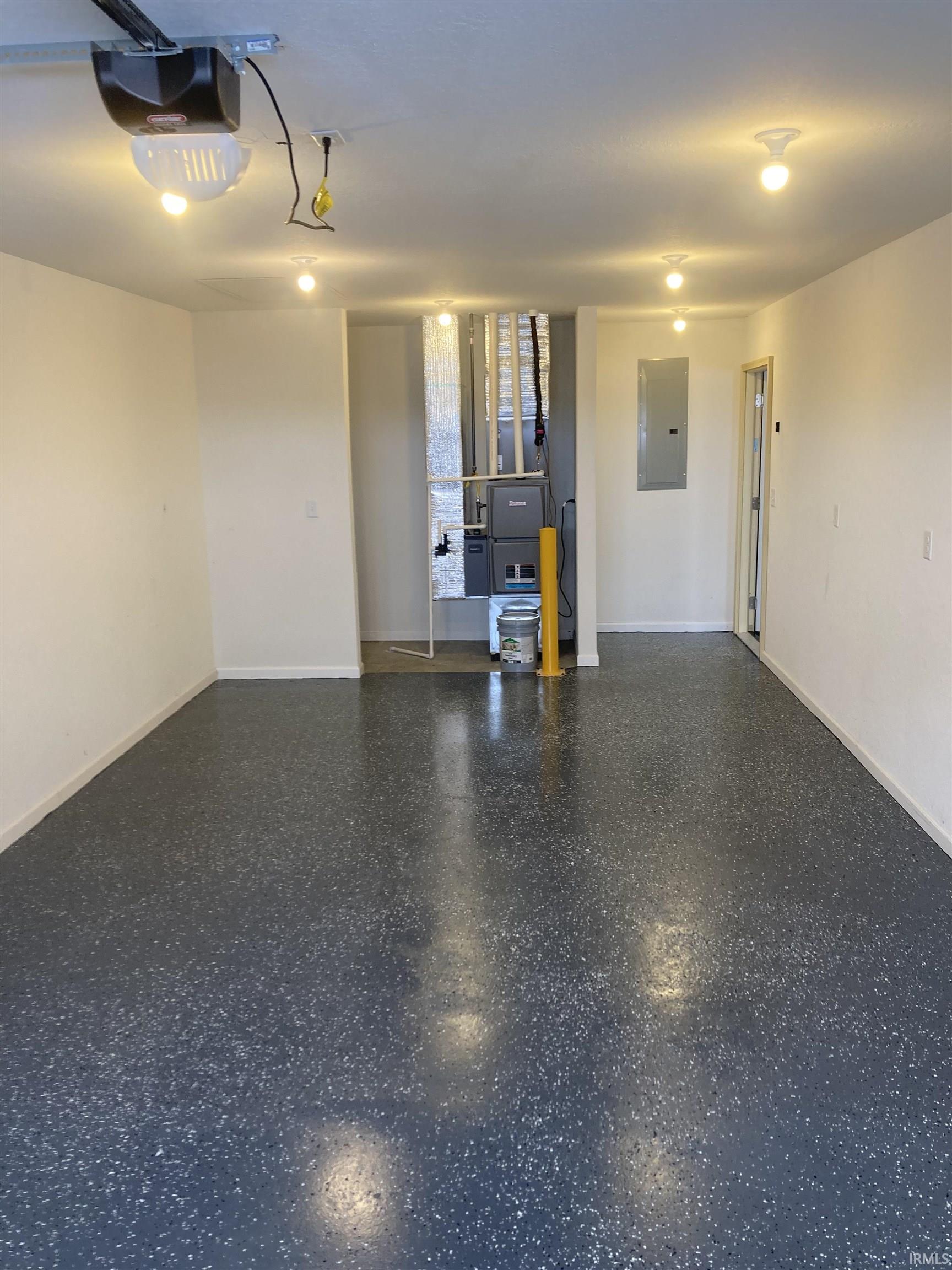 Garage with electric panel, a garage door opener, and heating unit