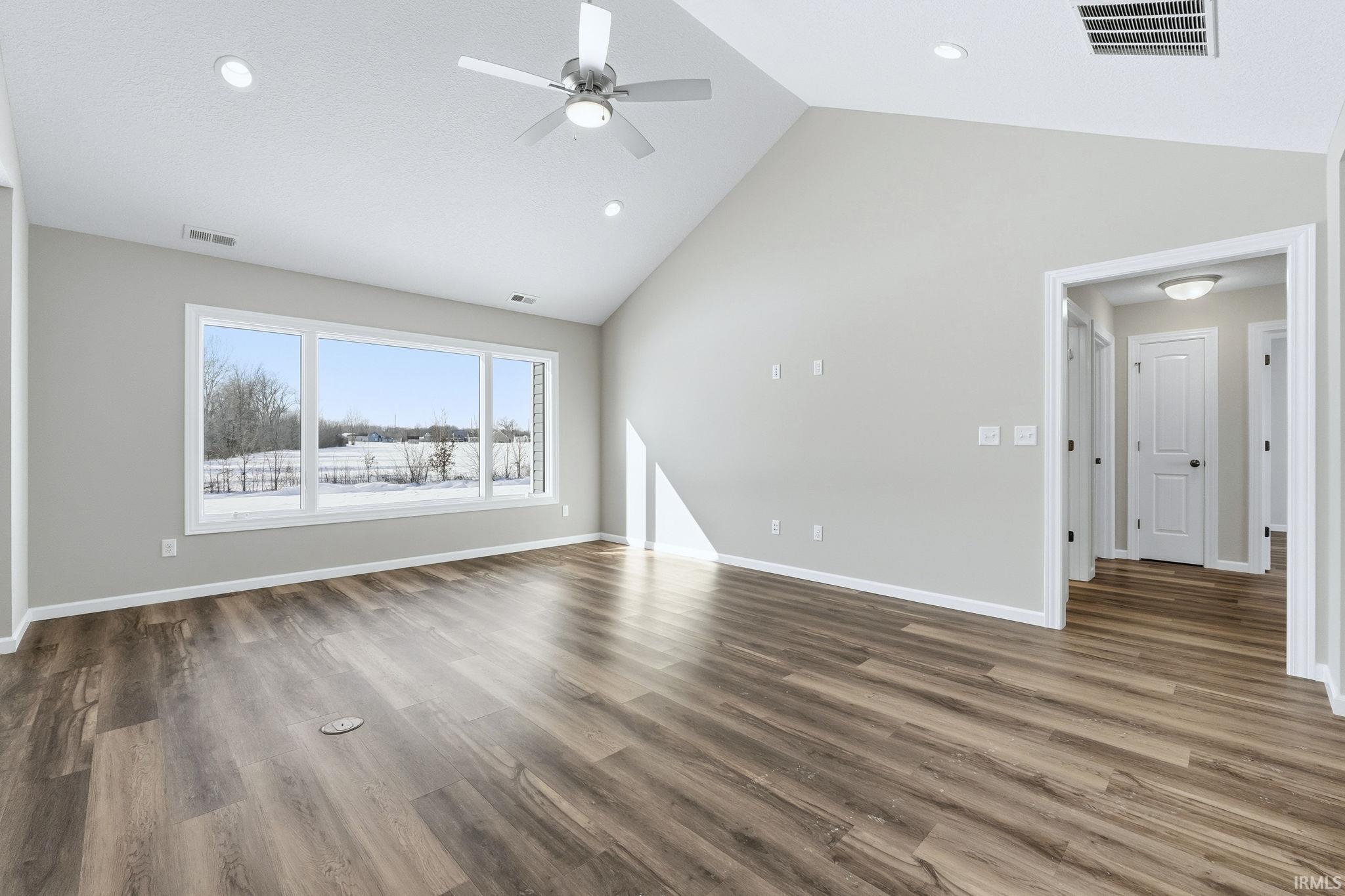 Unfurnished living room featuring a high ceiling, wood finished floors, recessed lighting, and ceiling fan