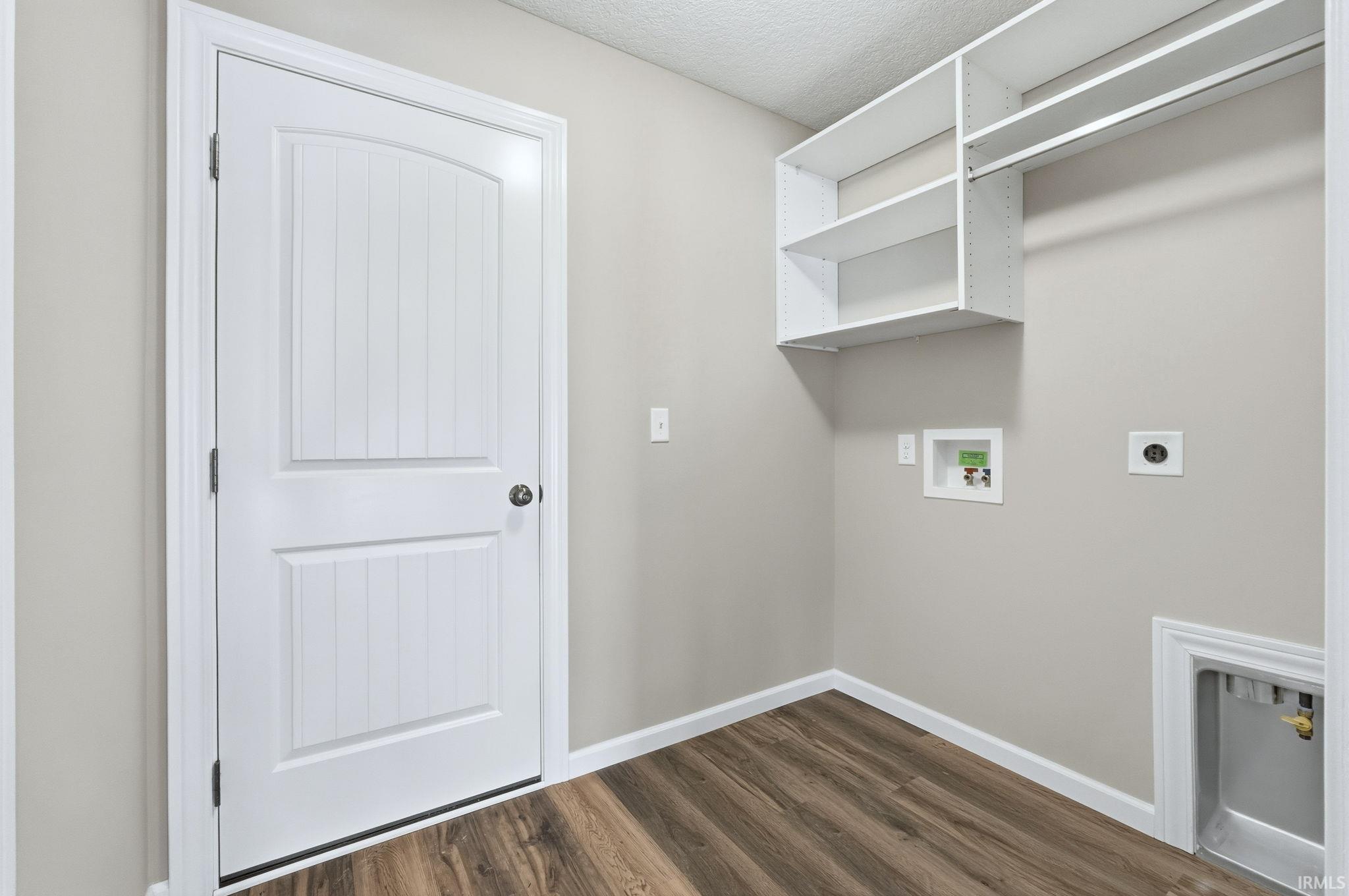 Laundry area featuring washer hookup, dark wood finished floors, hookup for an electric dryer, and a textured ceiling