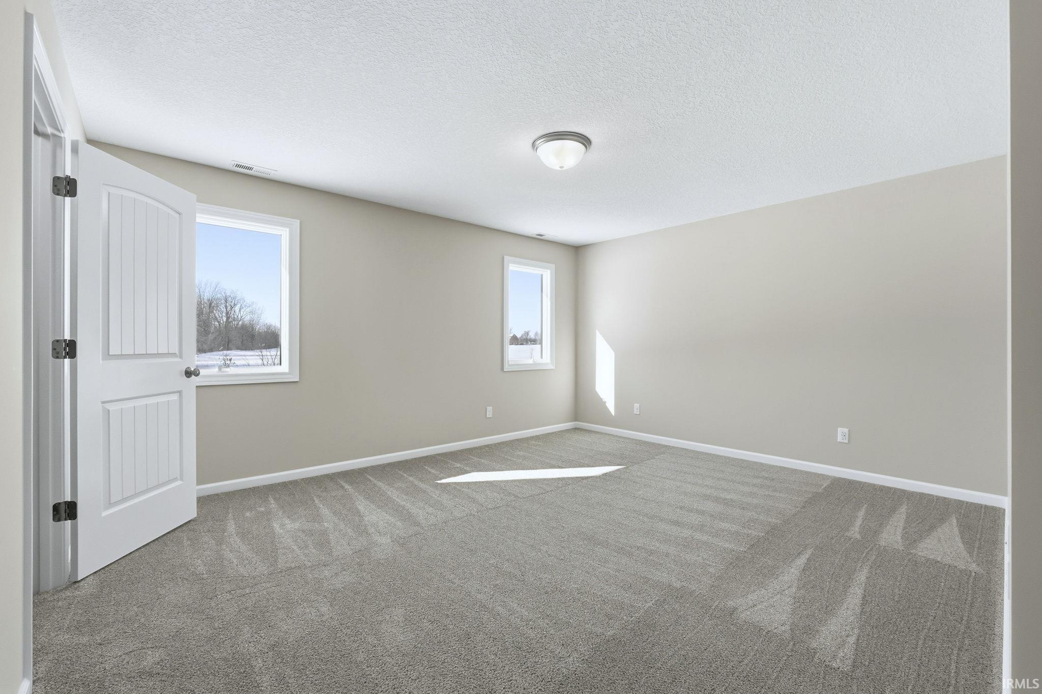 Spare room with carpet flooring and a textured ceiling