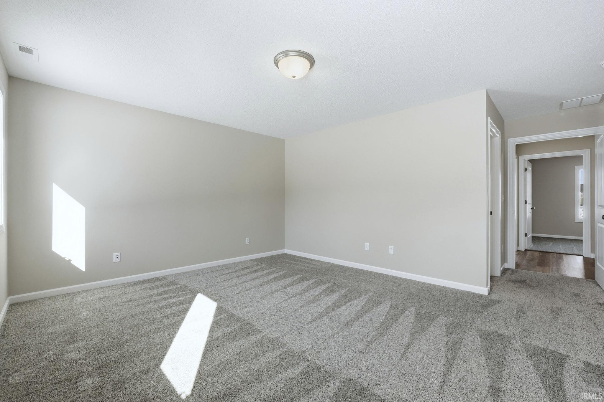 Empty room with carpet and baseboards