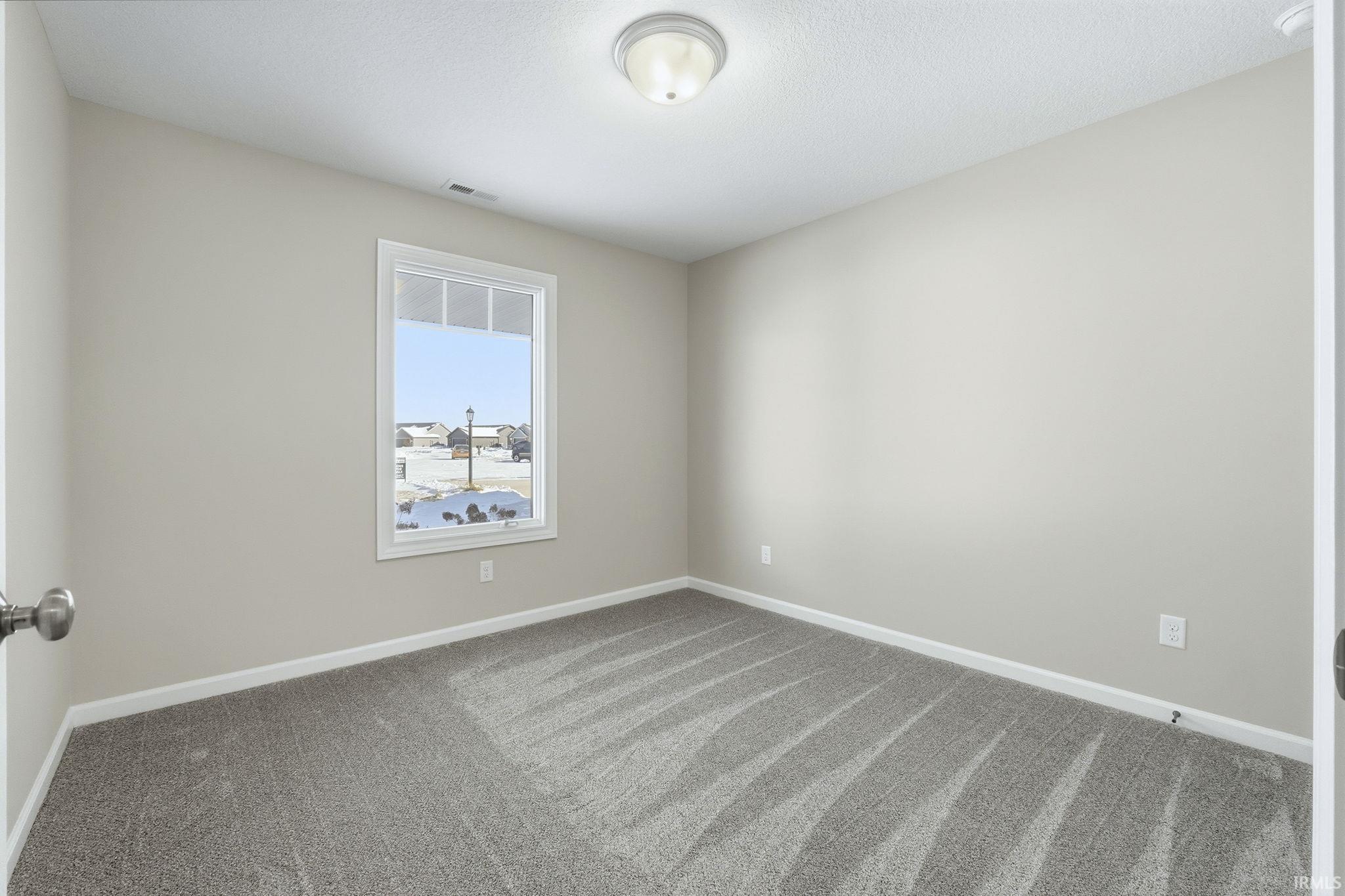 Empty room with carpet floors and baseboards