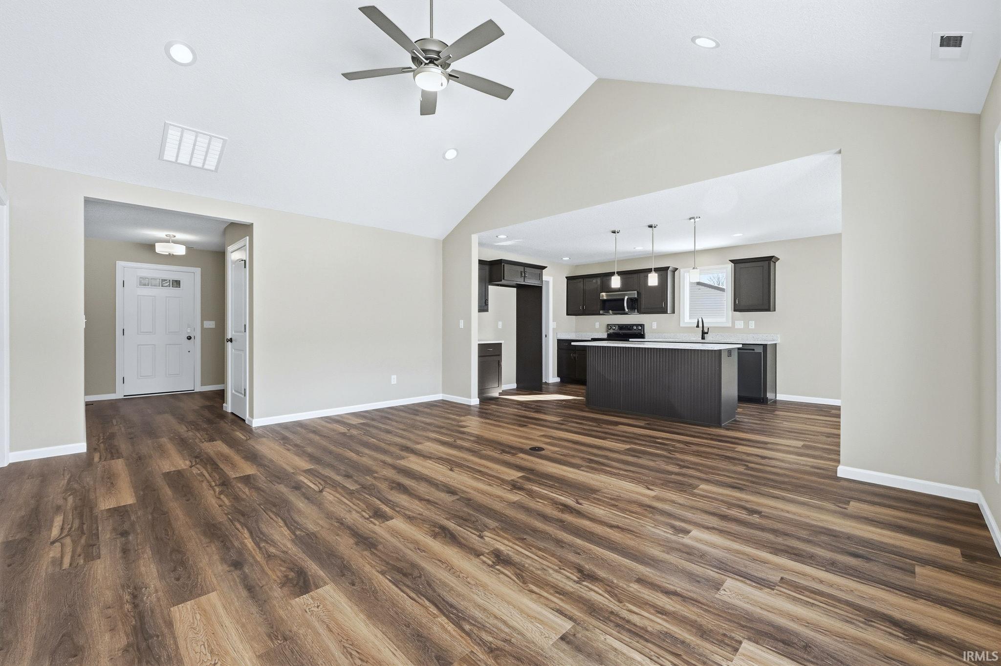 Unfurnished living room with a high ceiling, dark wood-type flooring, ceiling fan, and recessed lighting