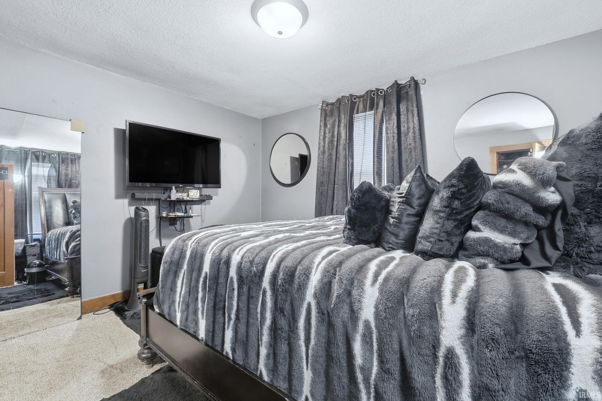 Bedroom featuring carpet and a textured ceiling