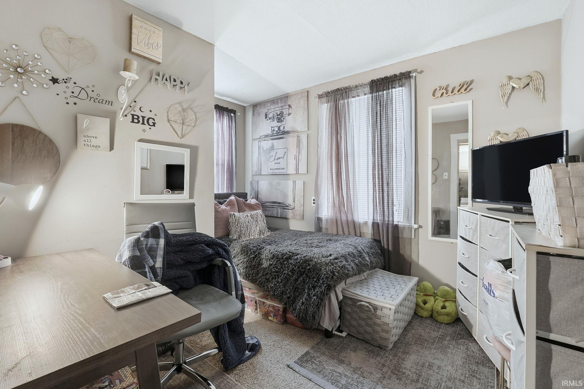 Carpeted bedroom with a desk