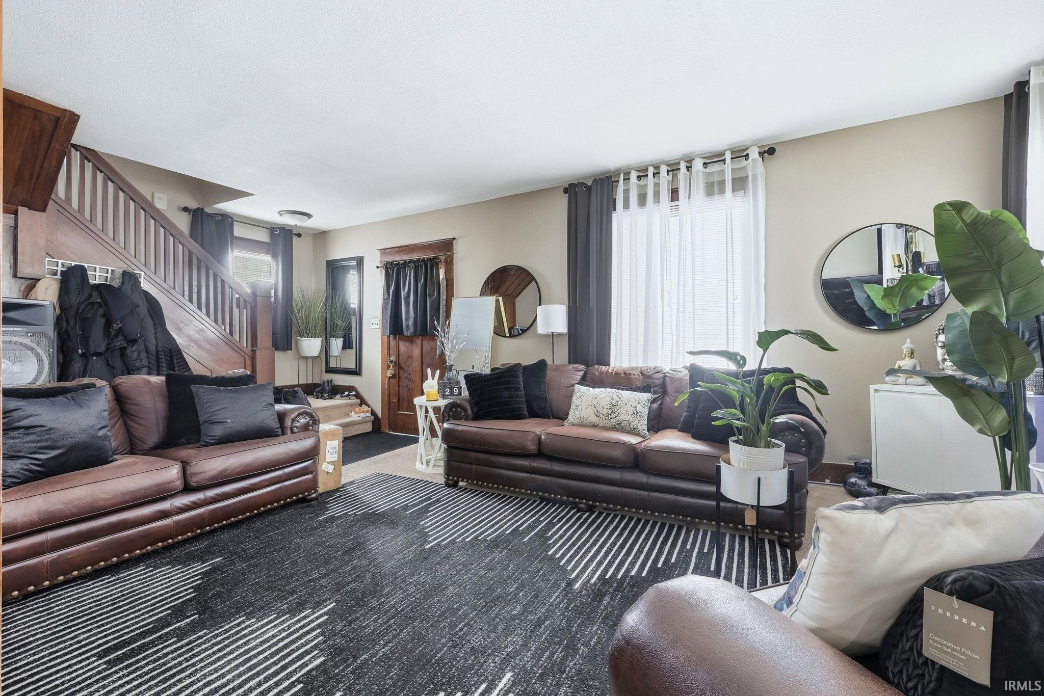 Carpeted living room with stairs