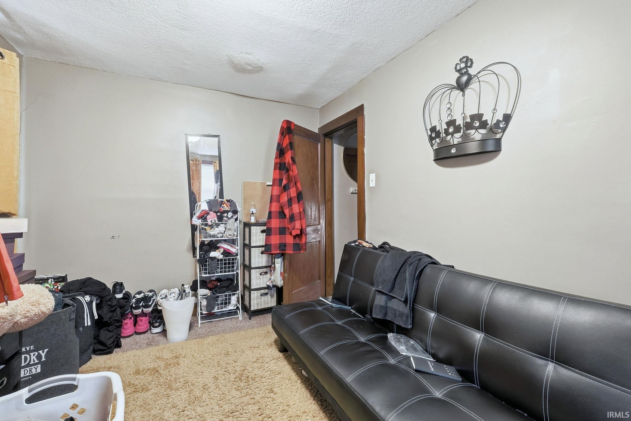 Carpeted living area with a textured ceiling
