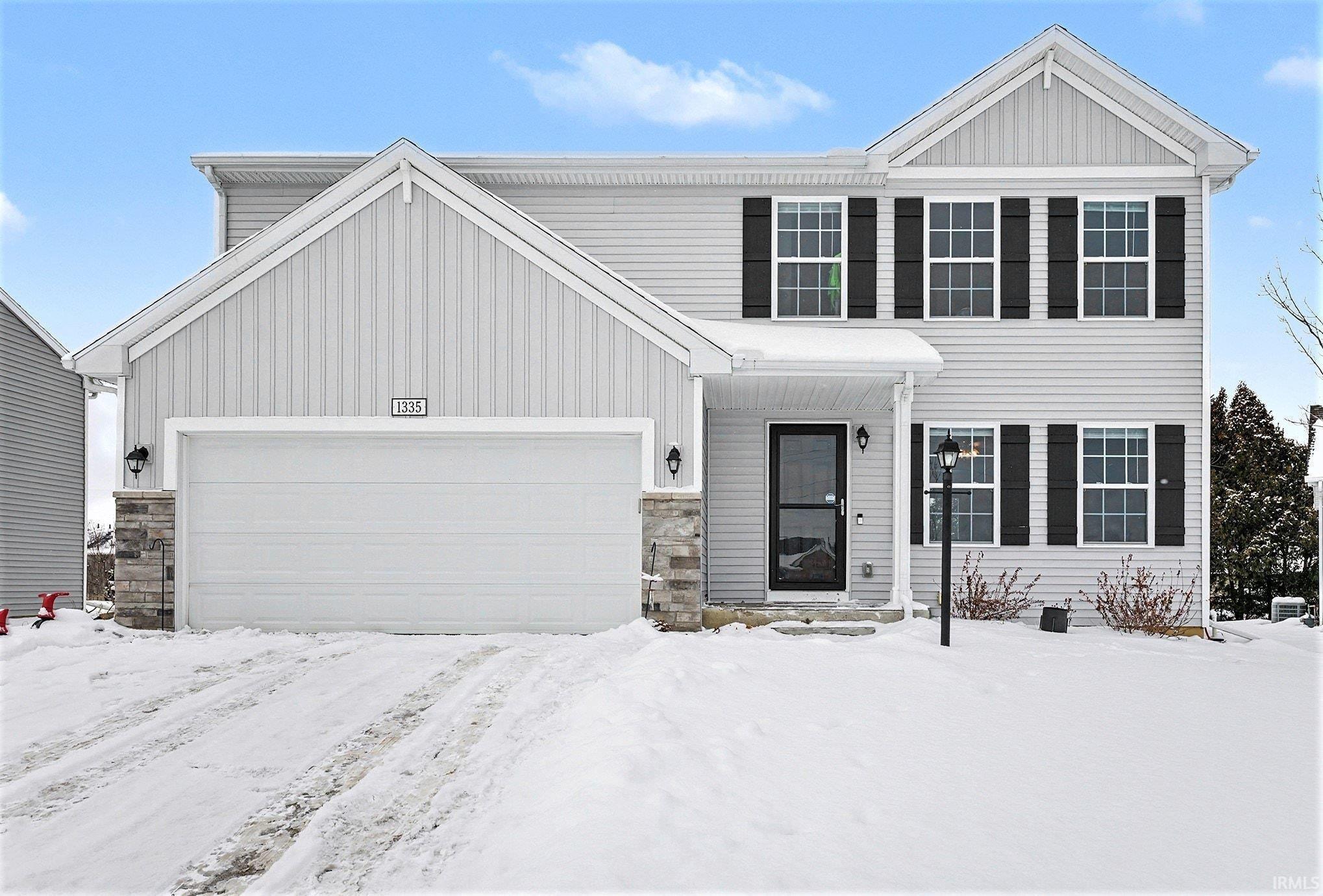 View of front of home featuring stone siding and a garage