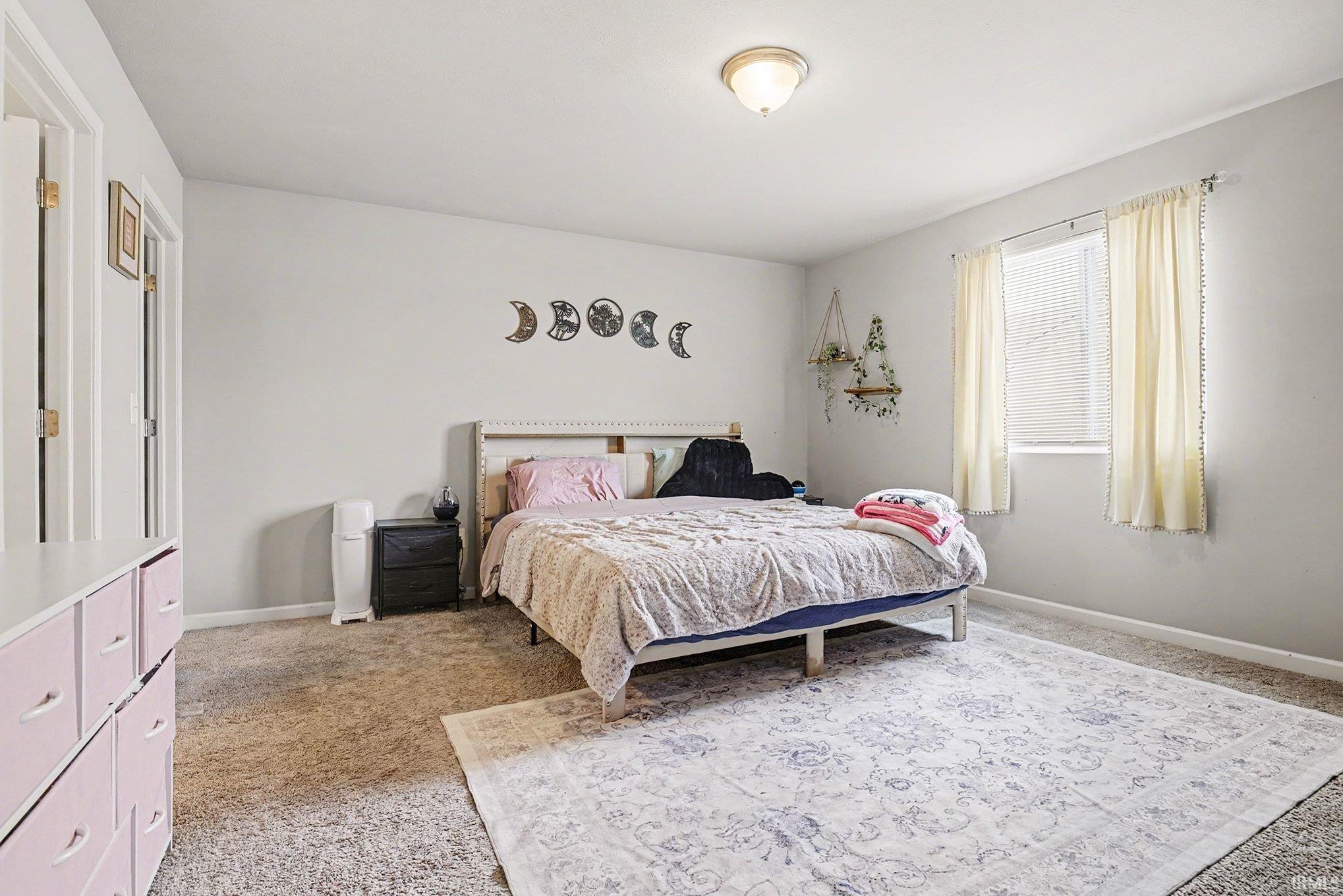 Bedroom featuring light colored carpet