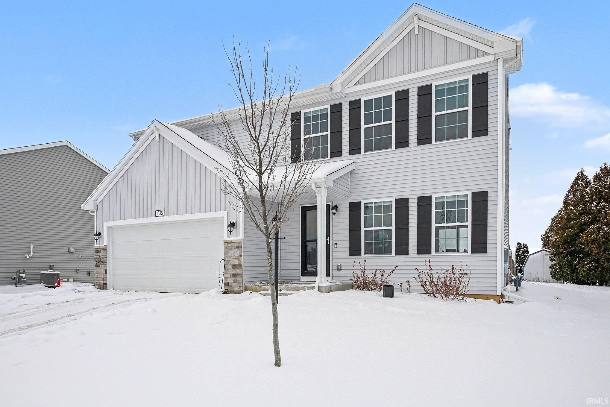 View of front of house with board and batten siding and a garage
