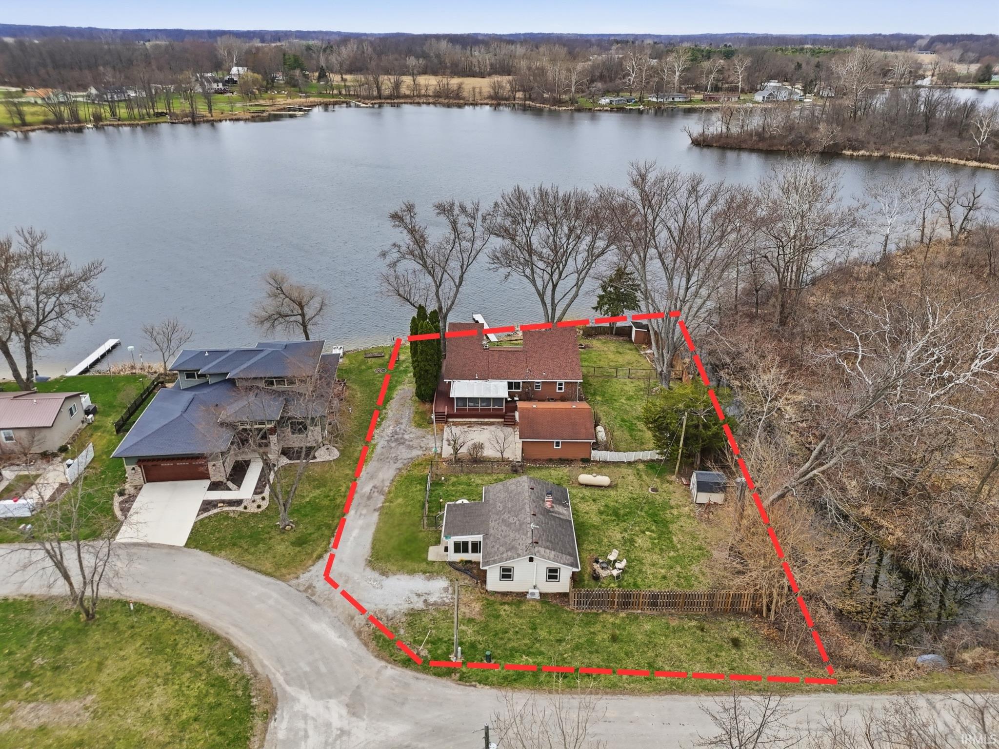 Aerial view of residential area featuring property parcel outlined and a large body of water