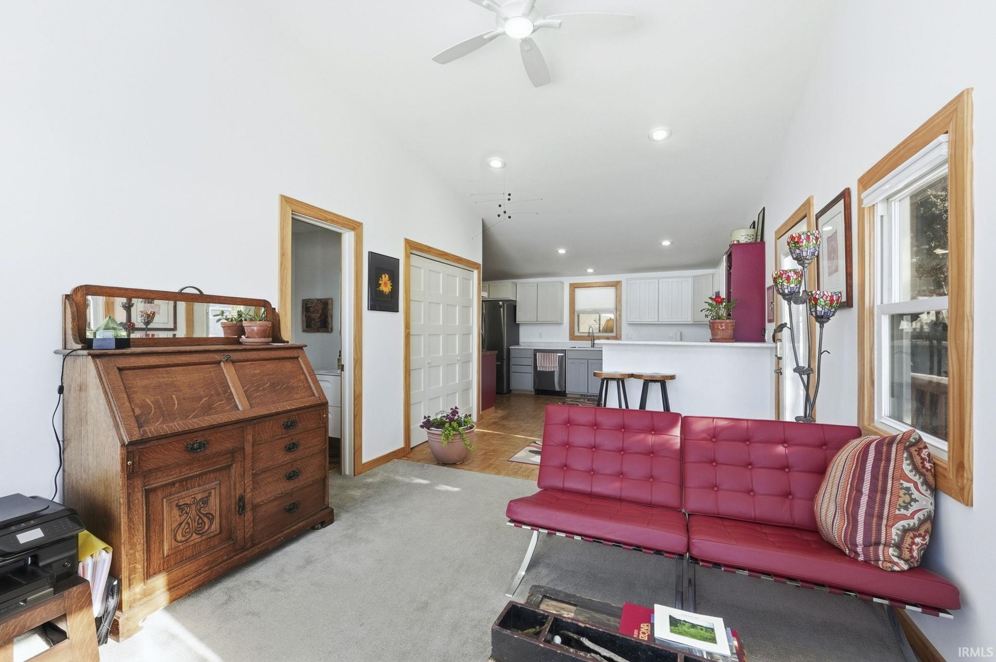 Living area with ceiling fan, light colored carpet, and recessed lighting