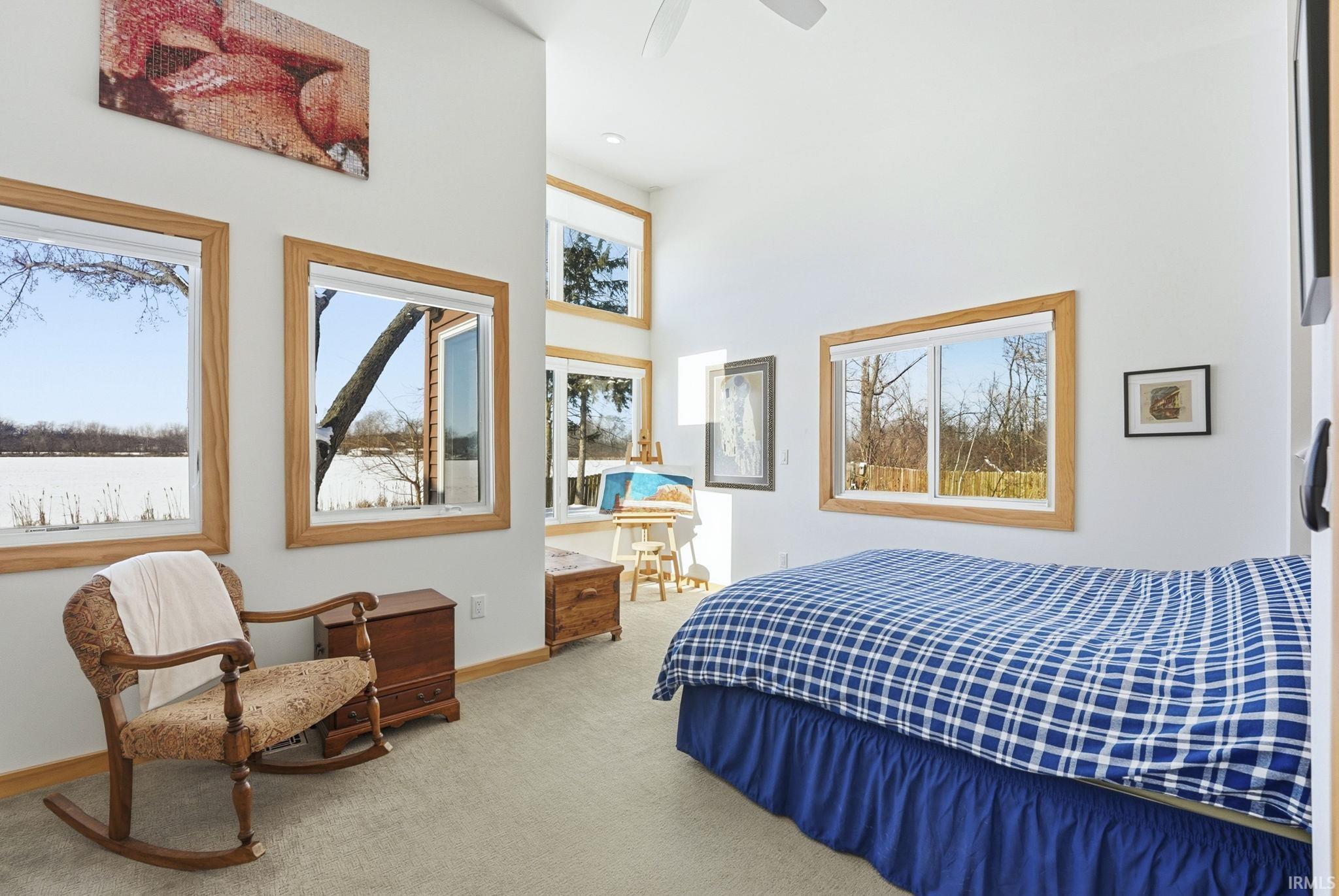 Bedroom featuring carpet floors, a ceiling fan, and a high ceiling