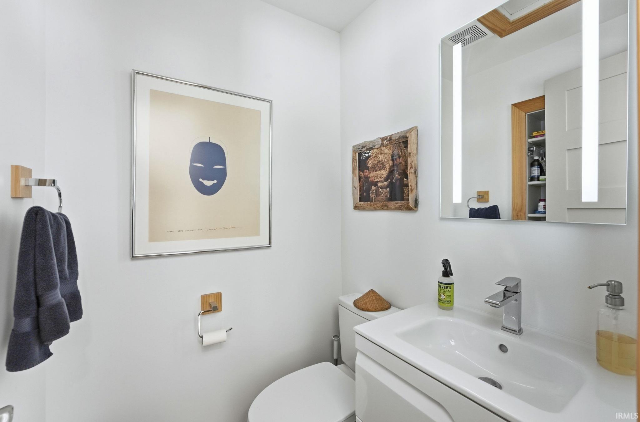 Half bathroom with vanity and toilet