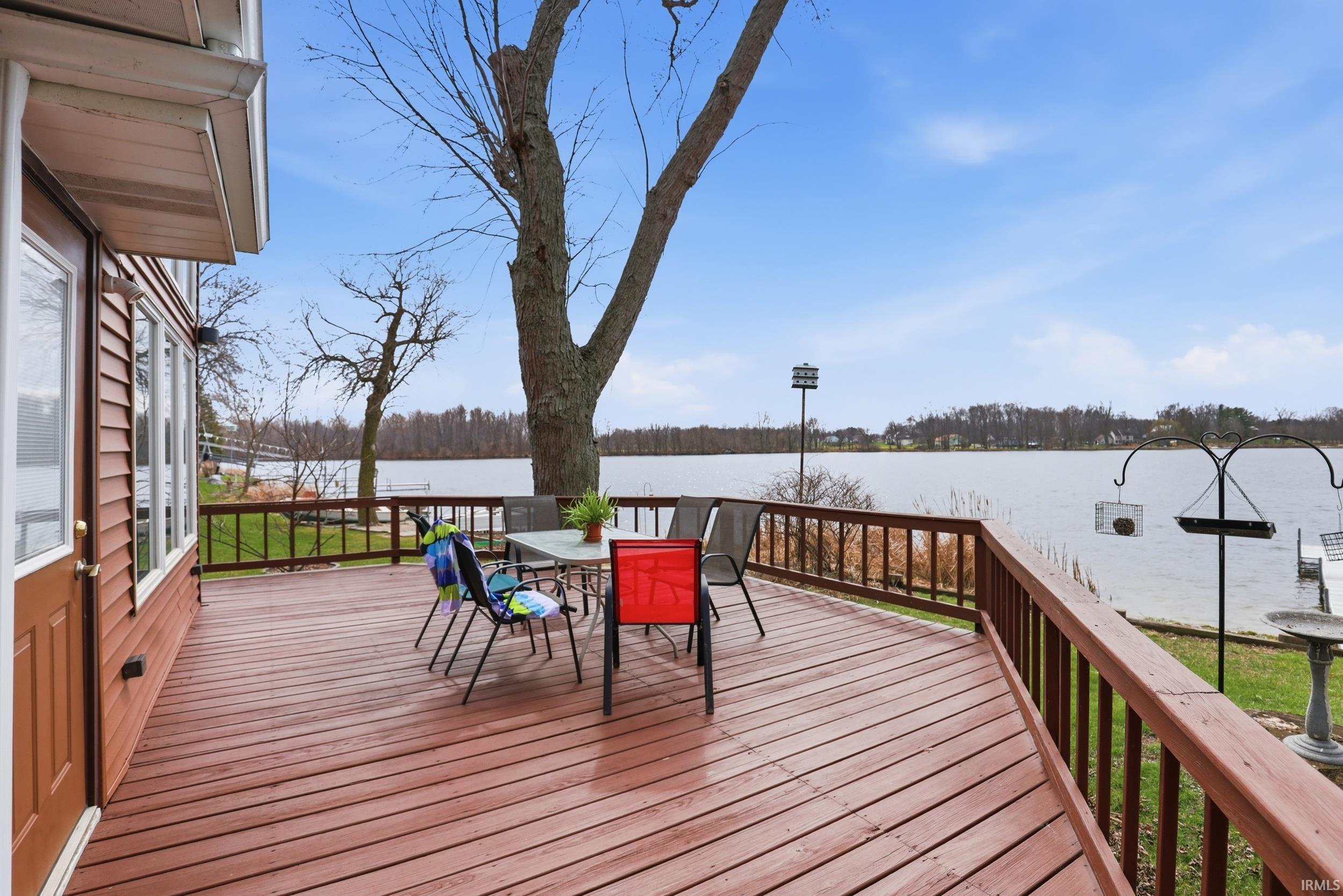 Wooden deck with outdoor dining space and a water view
