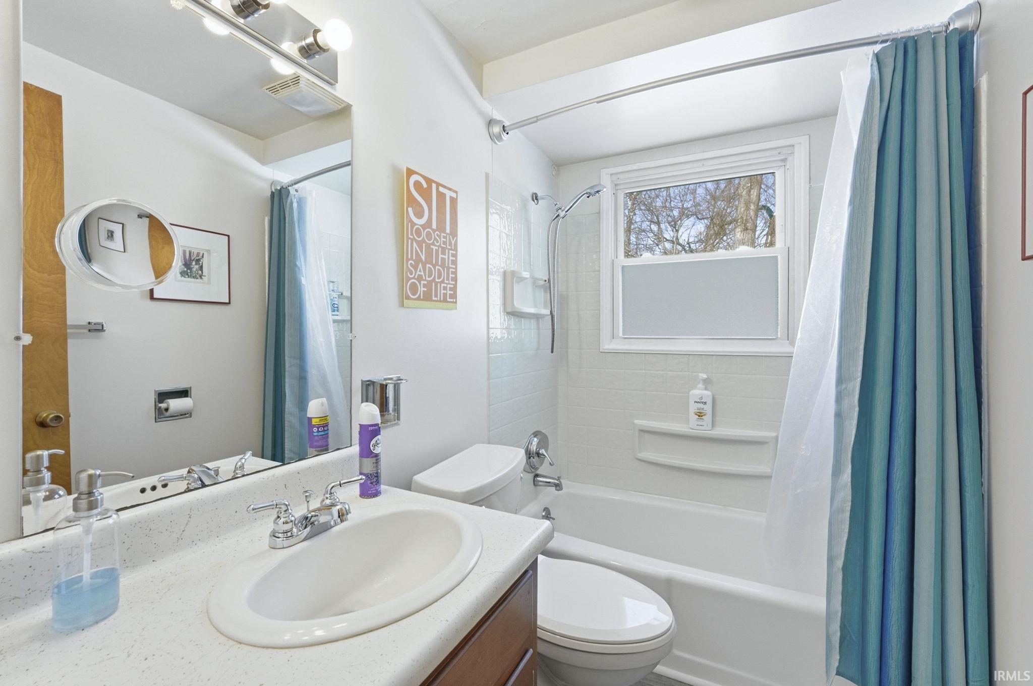 Bathroom featuring shower / bath combo and vanity