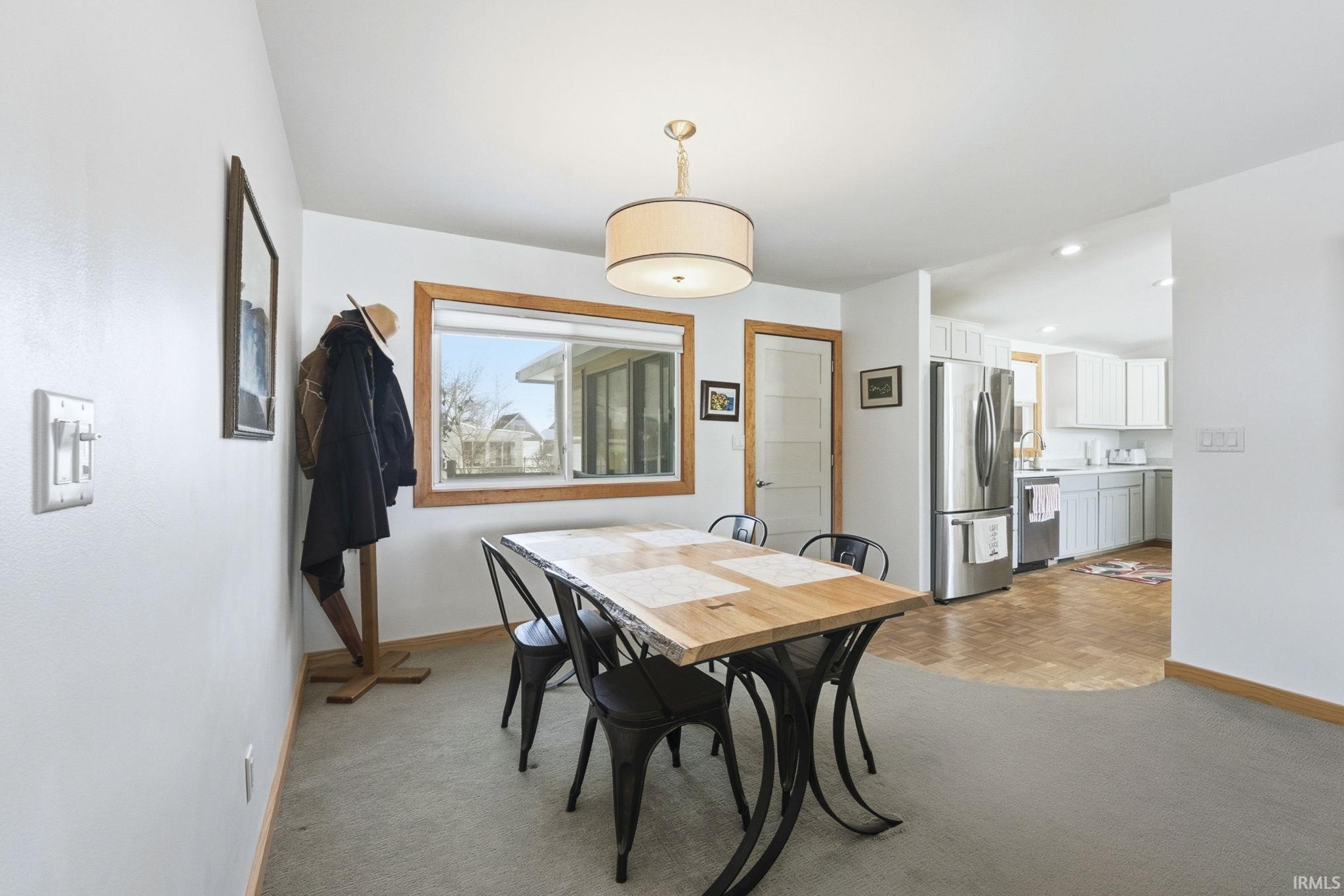 Dining room with parquet flooring, recessed lighting, and light colored carpet