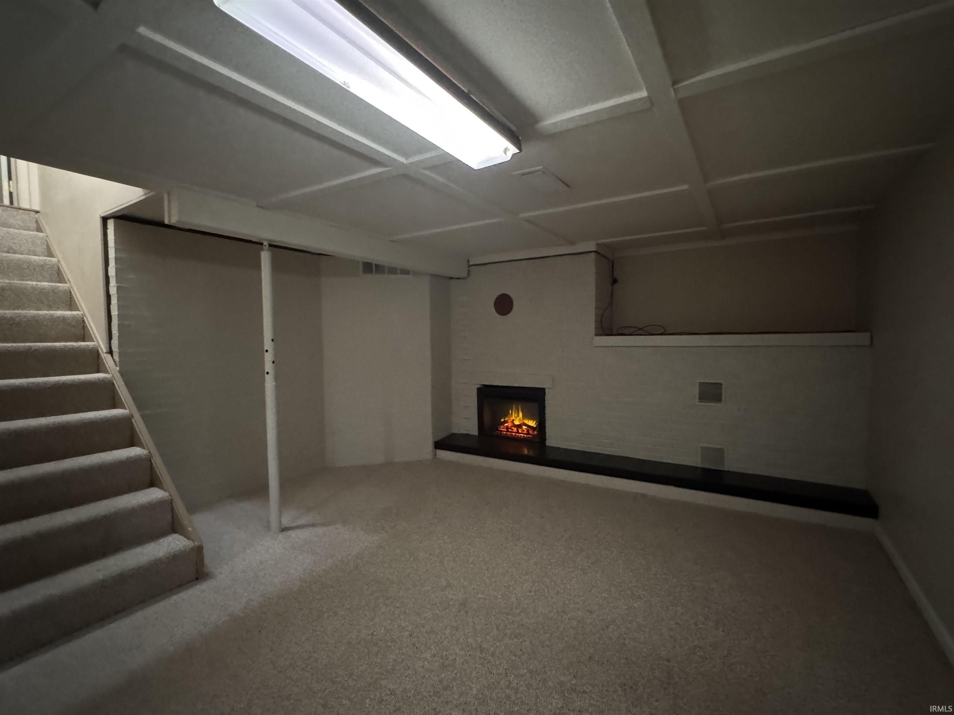 Finished basement featuring stairs, carpet floors, and a fireplace