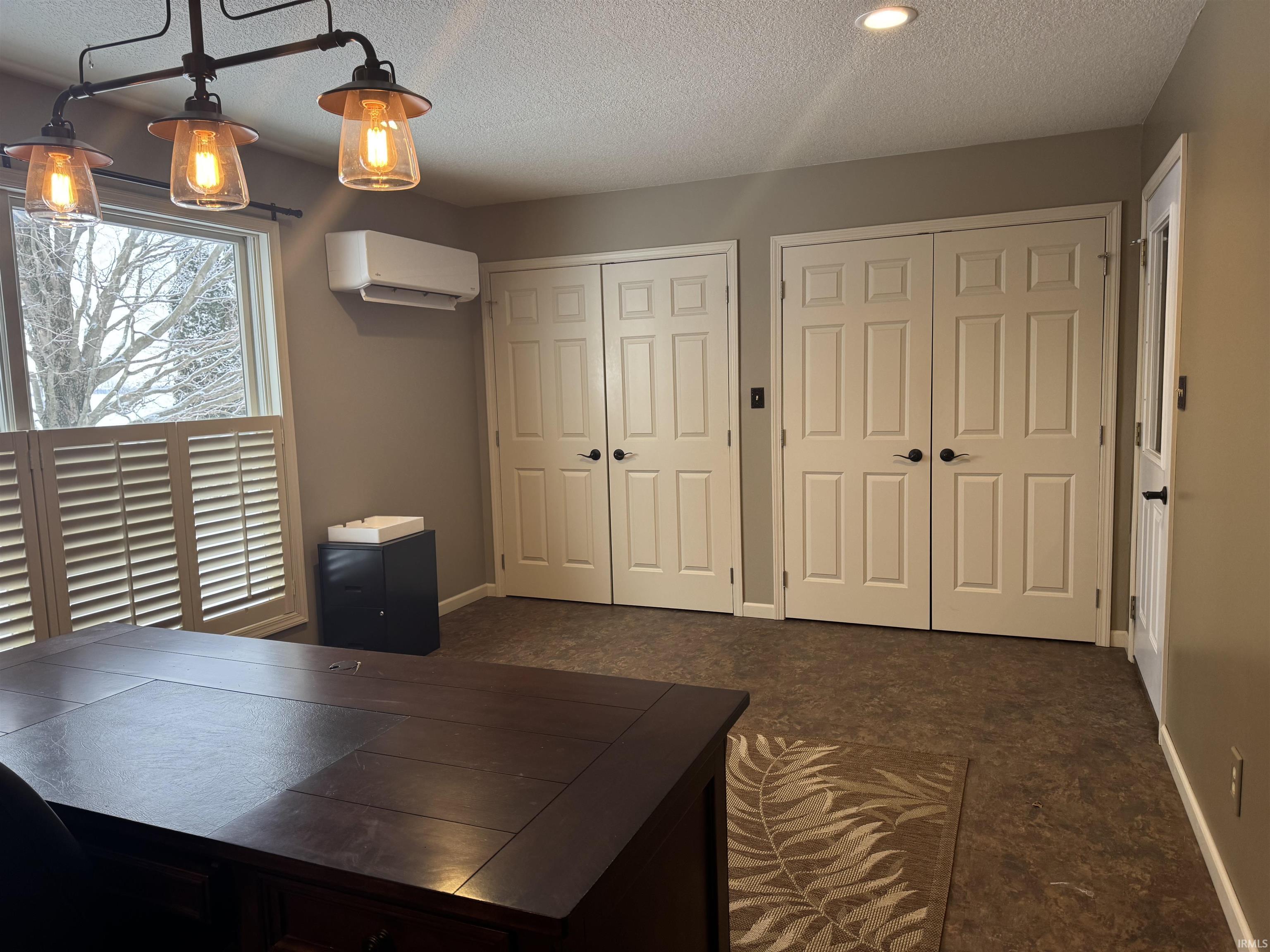 Office area featuring a textured ceiling and a wall mounted AC