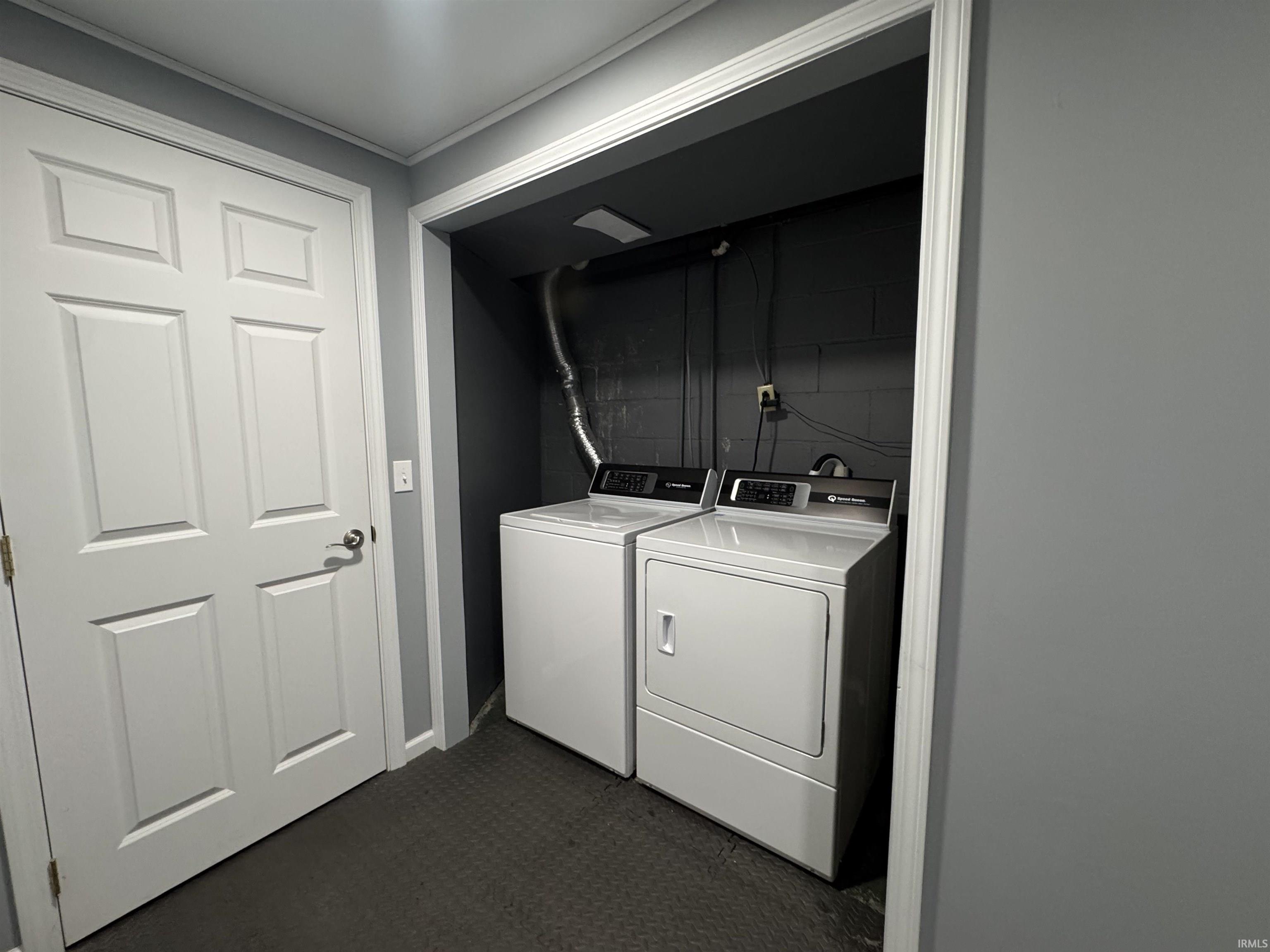 Laundry area featuring washing machine and dryer and baseboards