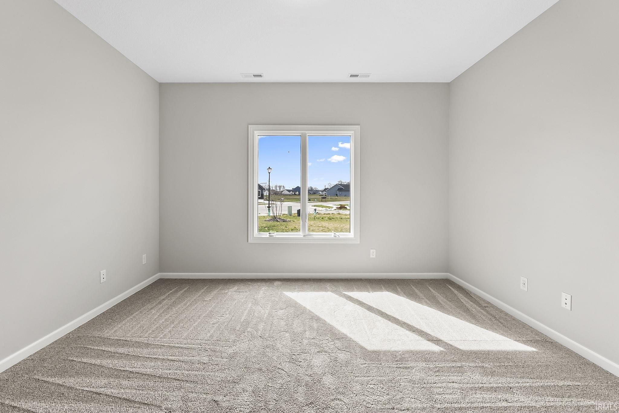Spare room with baseboards and light carpet
