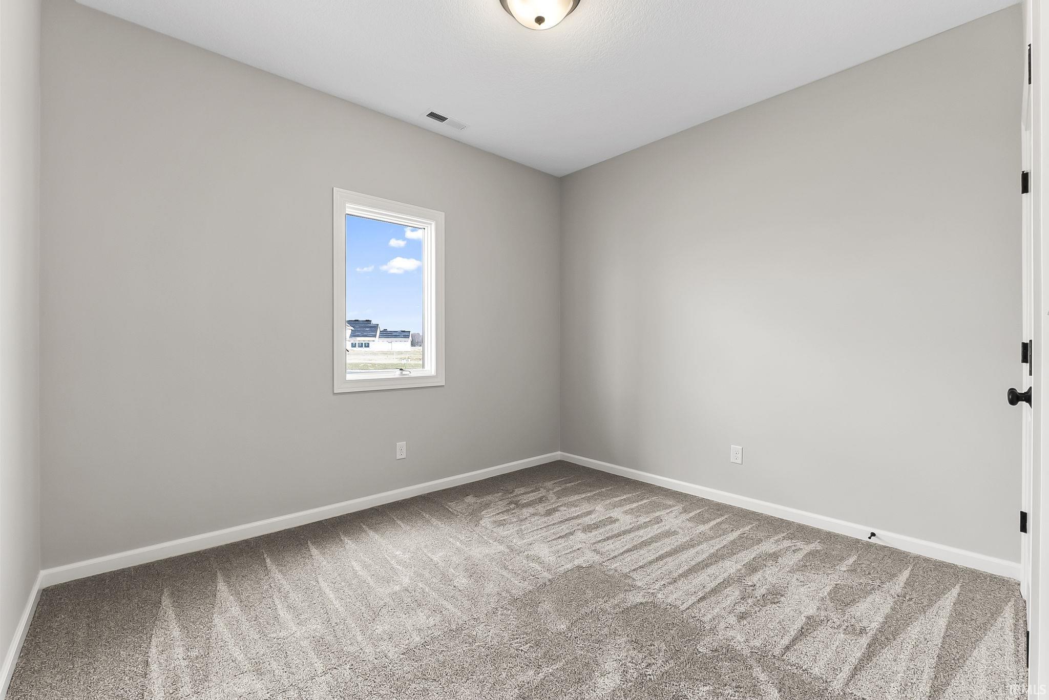 Unfurnished room with light colored carpet and baseboards