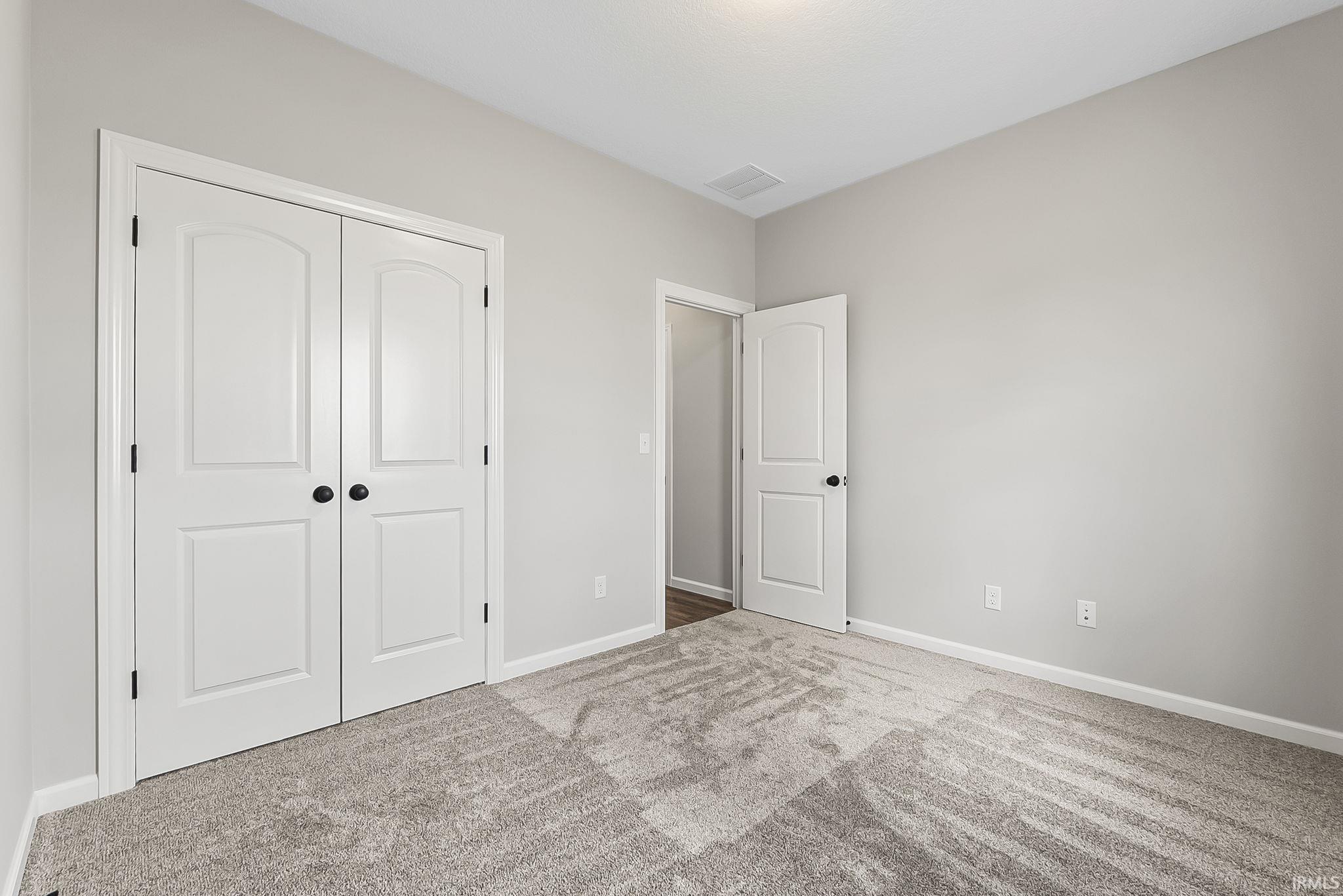 Unfurnished bedroom featuring carpet flooring and a closet