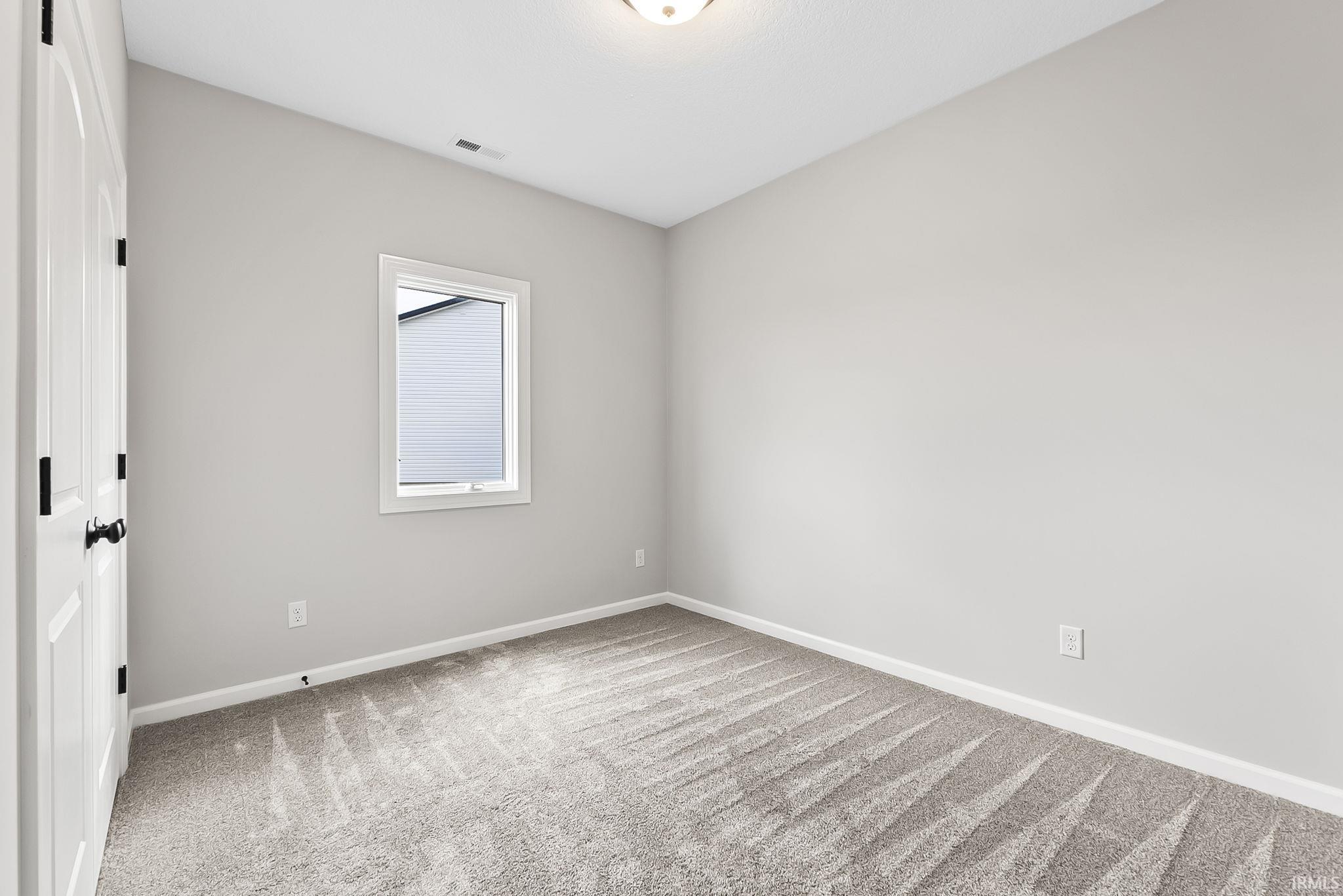 Spare room with baseboards and light carpet