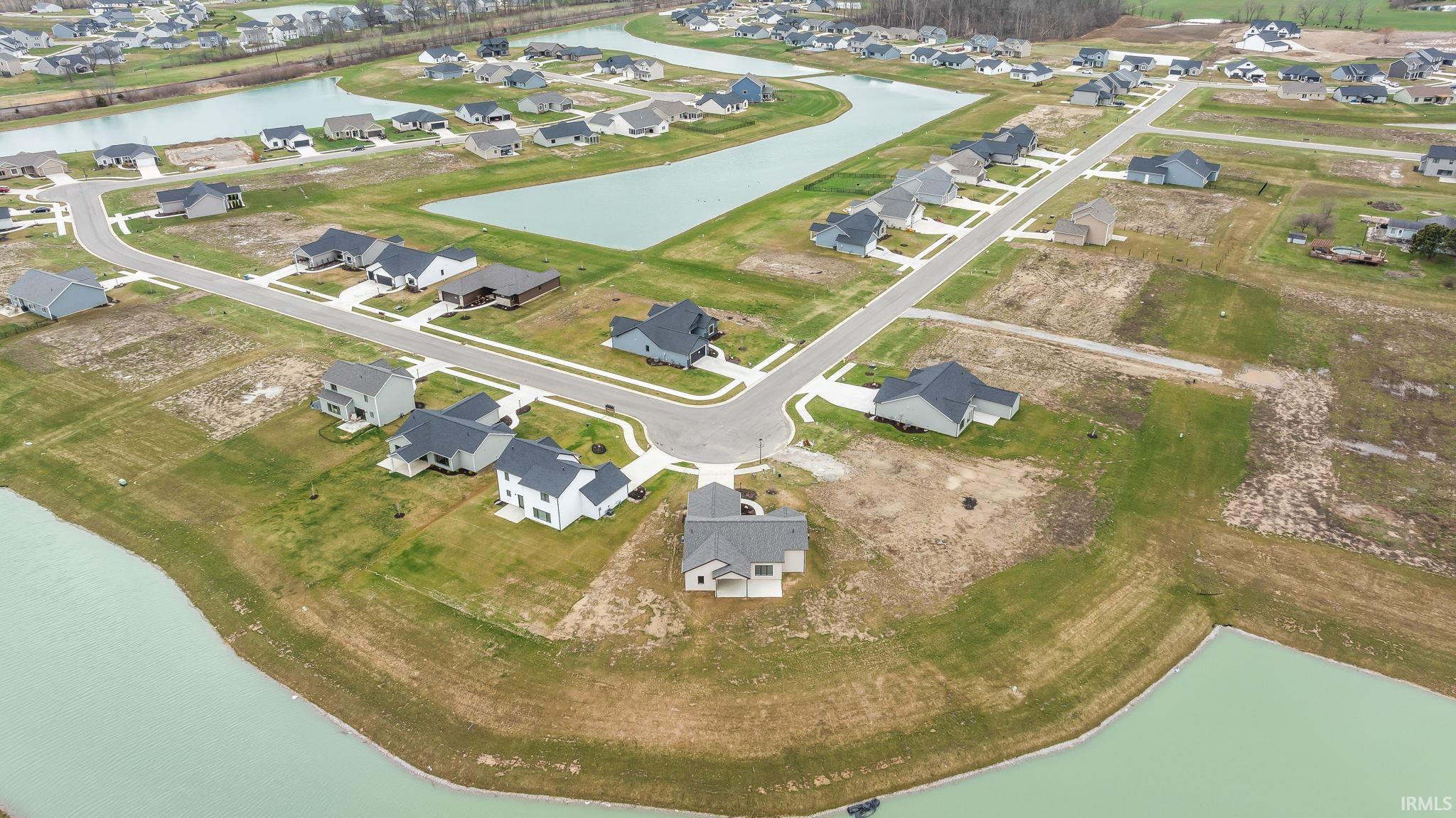 Aerial view of property and surrounding area with a large body of water and nearby suburban area