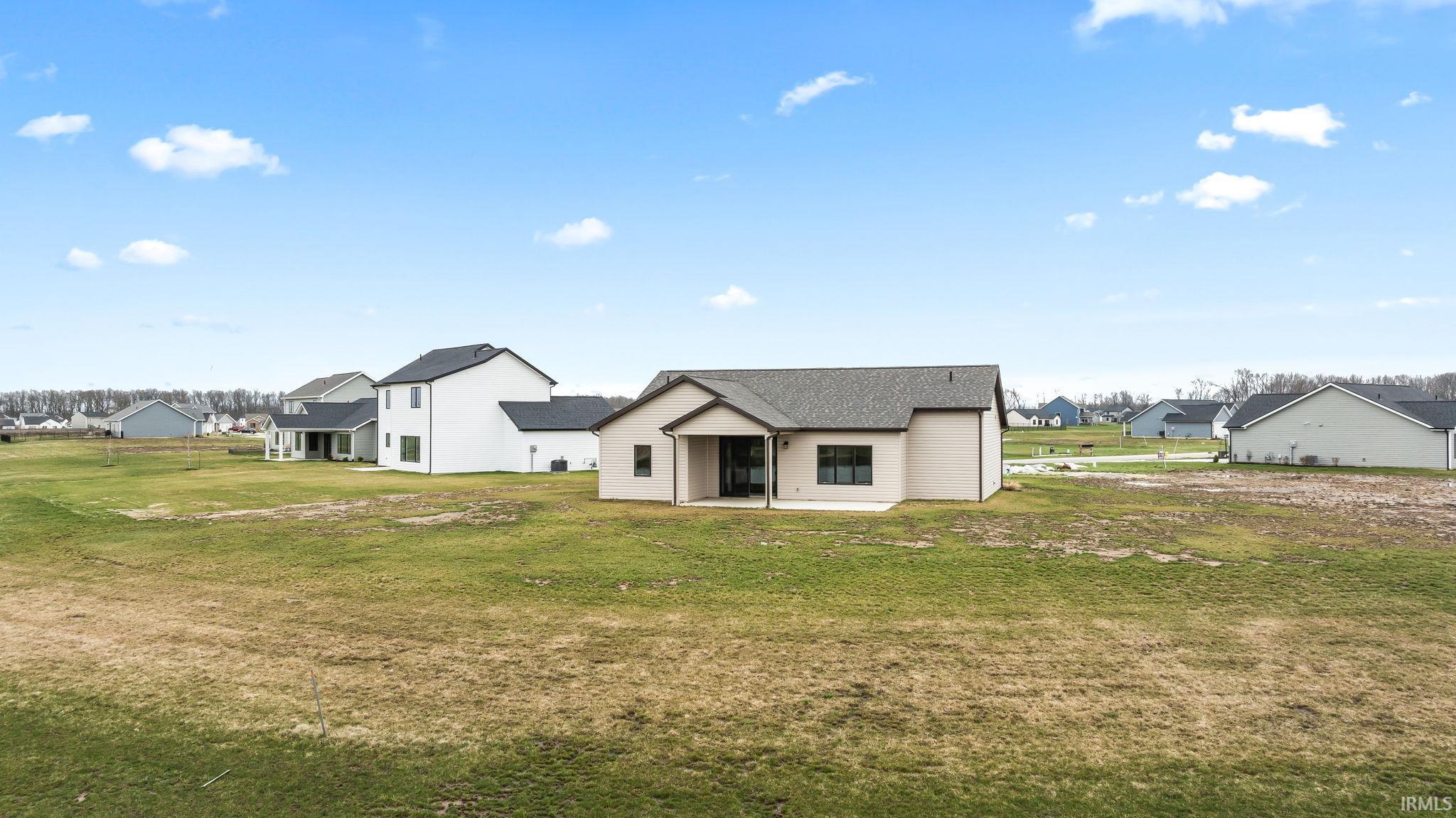 Back of property featuring a residential view, a patio, and a yard